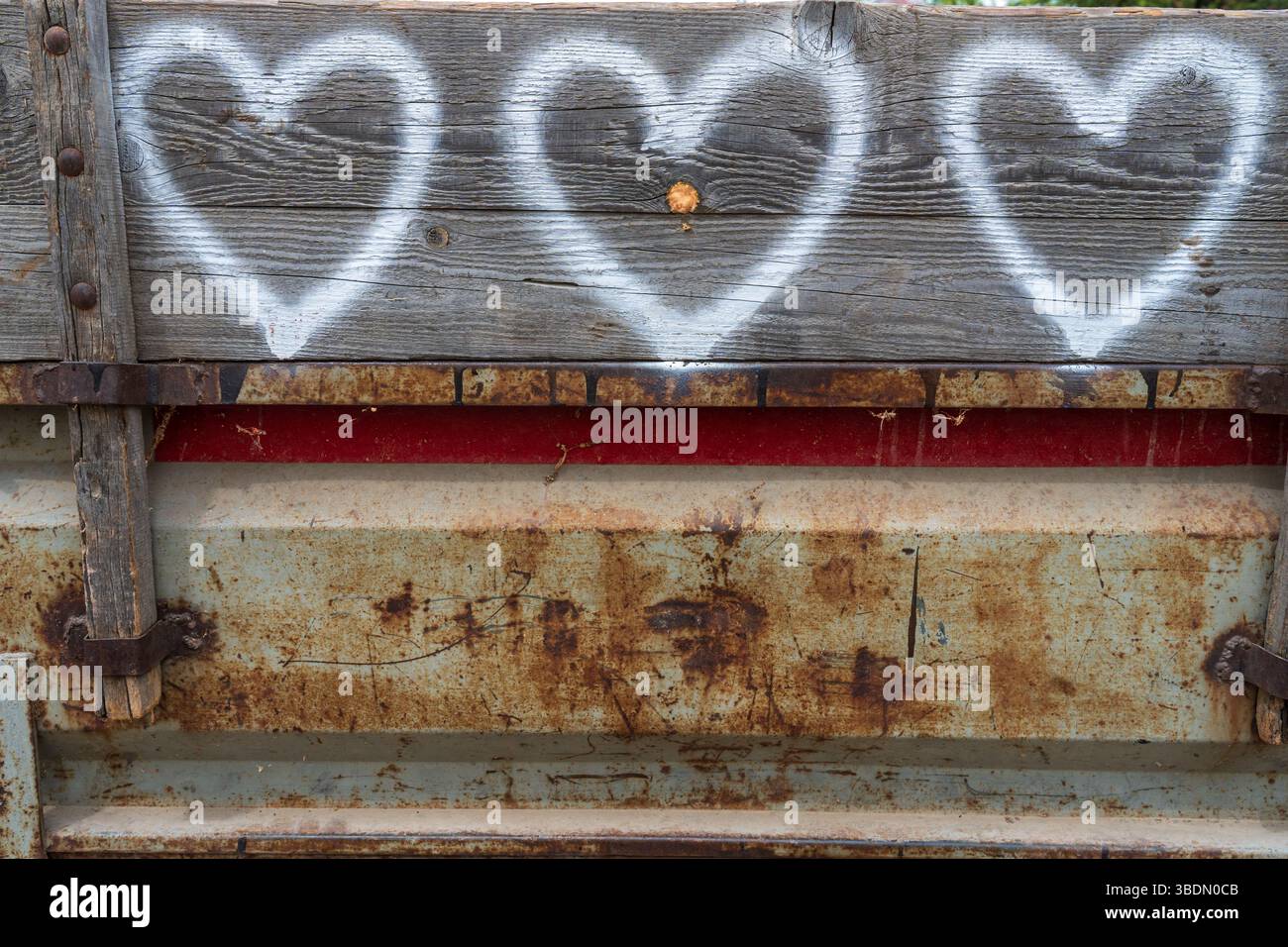 Tre cuori bianchi su un rimorchio per trattori in legno. Primo piano, prospettiva. Foto Stock