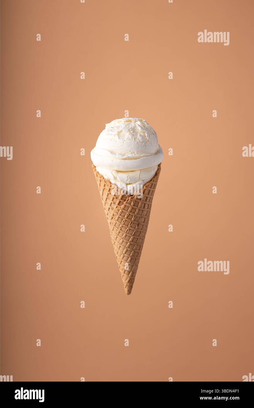 Cucchiaio per gelato con cono per gelato su sfondo luminoso. Concetto estivo minimalista. Foto Stock
