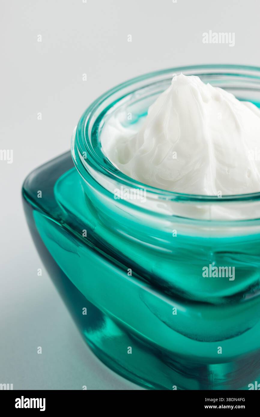 Barattolo di crema cosmetica su sfondo grigio. Crema di bellezza organica idratante. Idratante cura naturale della pelle. Concetto di Spa. Foto Stock