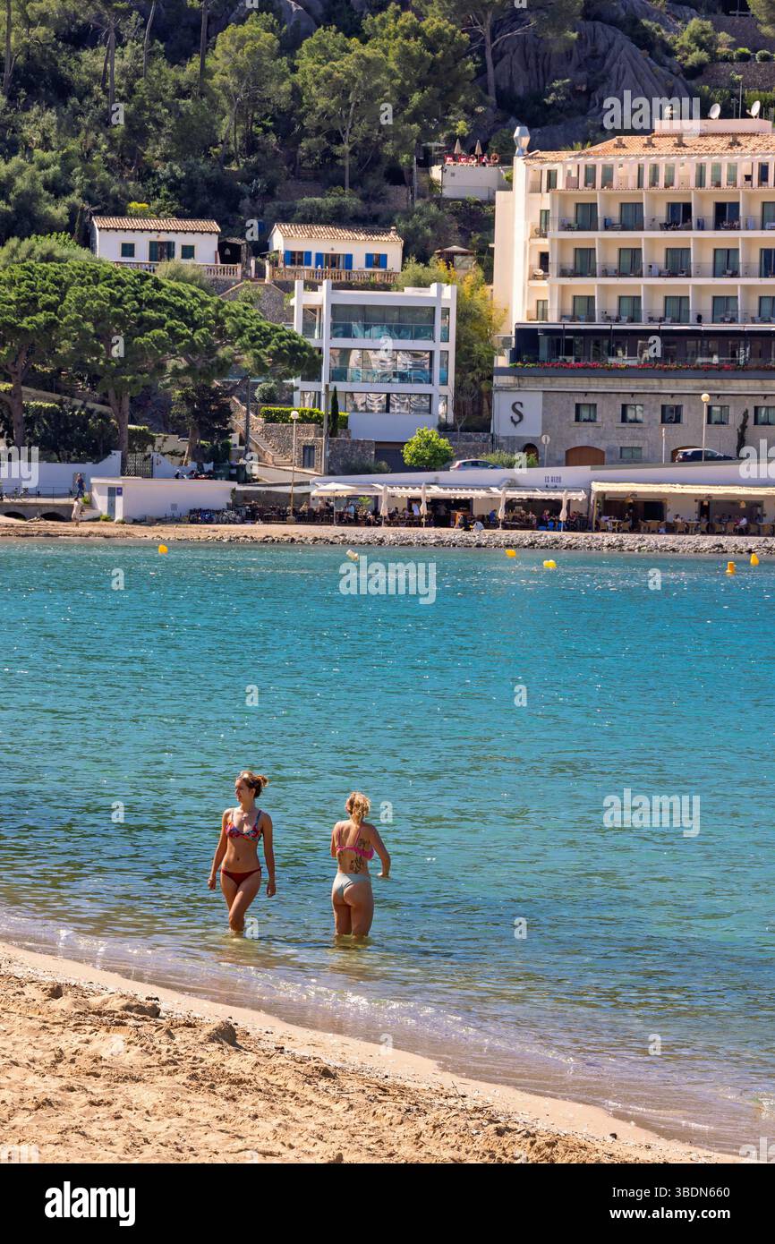 Donne in acqua su una spiaggia di sabbia in riva al mare una giornata estiva di sole Foto Stock
