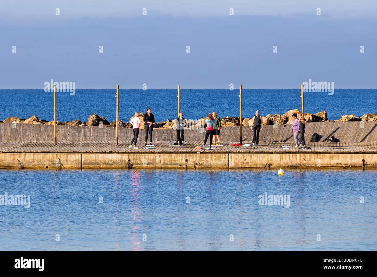 Gruppo di formazione con sole donne su un molo vicino al mare Foto Stock