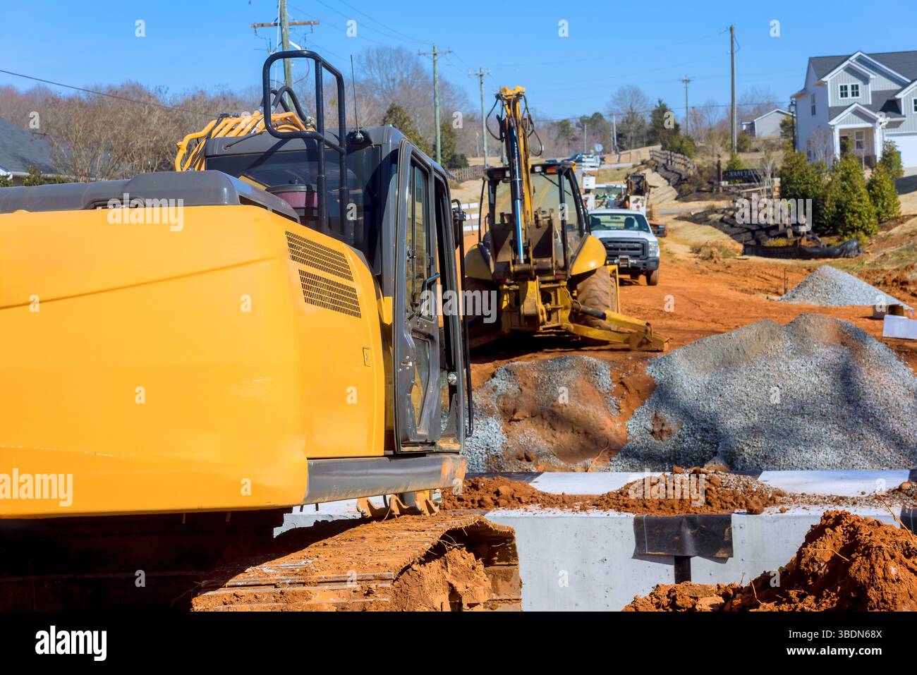I macchinari pesanti sono attivamente impegnati nella costruzione di siti residenziali nell'area di avanzamento lavori. Foto Stock