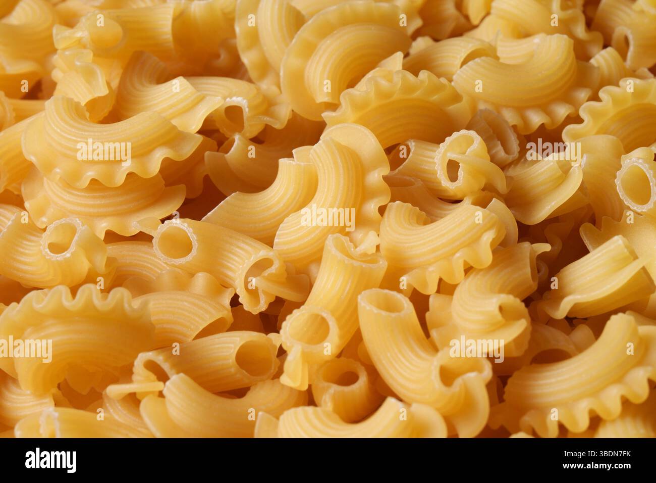 Pasta smerlata secca. La consistenza dei tagliatelle pastose, lo sfondo dei tagliatelle. Foto Stock