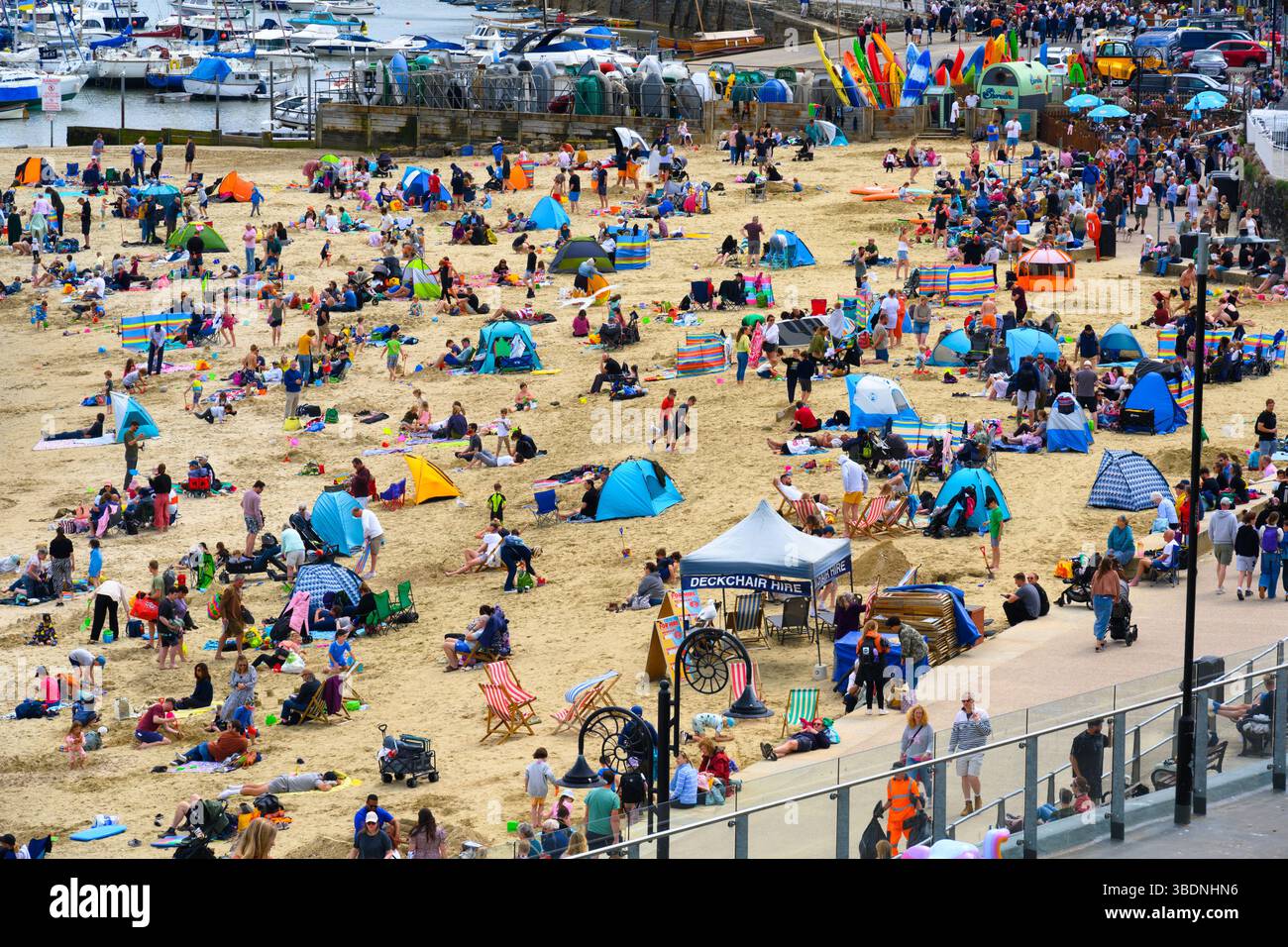 Lyme Regis, Dorset, Regno Unito. 25 maggio 2025. Meteo nel Regno Unito. Le famiglie e i vacanzieri affollano la spiaggia affollata della località balneare di Lyme Regis durante il fine settimana di vacanza. Con le previsioni del tempo variabili per il resto della pausa di metà periodo, la gente stava sfruttando al meglio le calde e soleggiate incantesimi di domenica pomeriggio. Crediti: Celia McMahon/Alamy Live News Foto Stock
