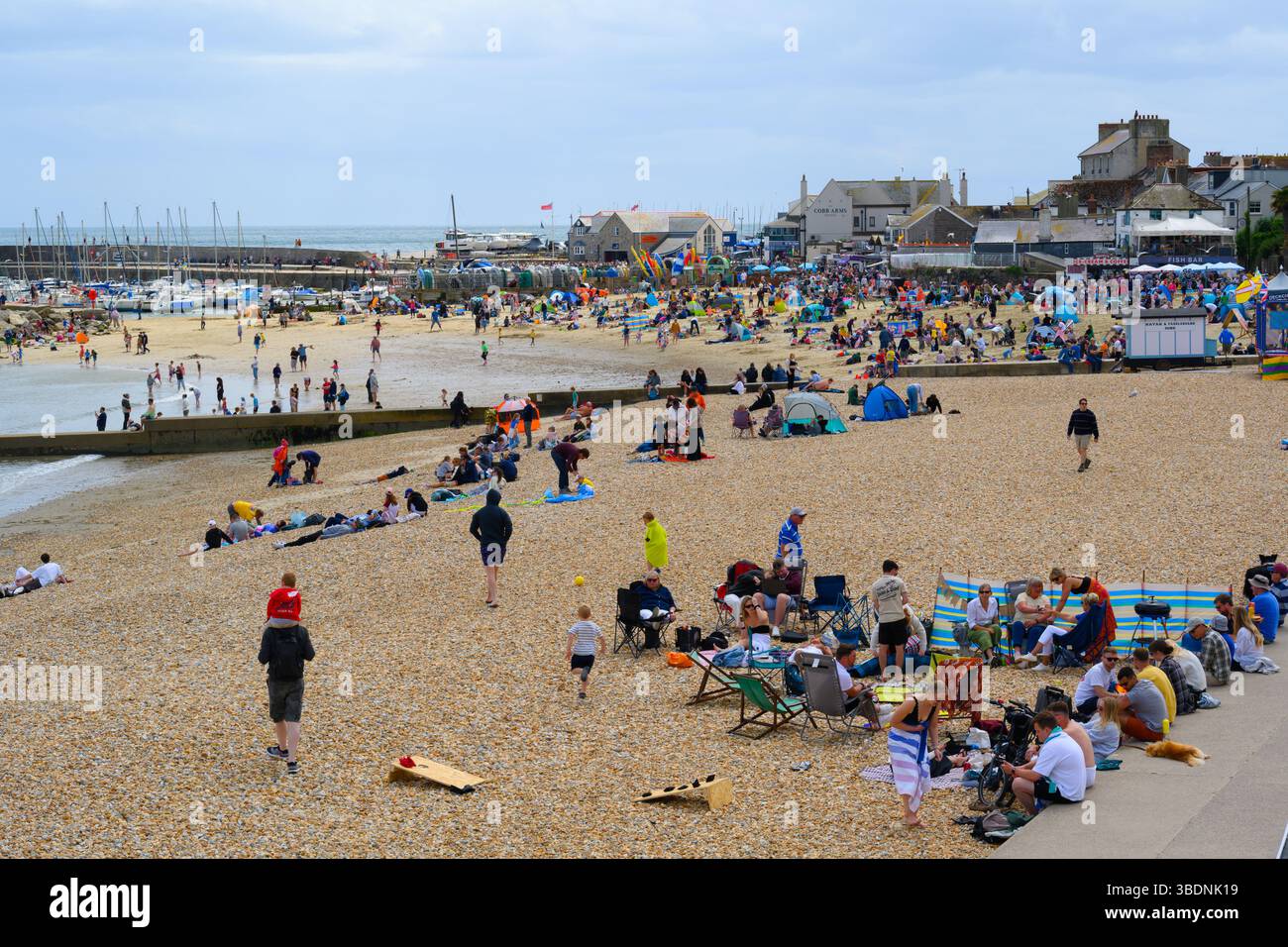 Lyme Regis, Dorset, Regno Unito. 25 maggio 2025. Meteo nel Regno Unito. Le famiglie e i vacanzieri affollano la spiaggia affollata della località balneare di Lyme Regis durante il fine settimana di vacanza. Con le previsioni del tempo variabili per il resto della pausa di metà periodo, la gente stava sfruttando al meglio le calde e soleggiate incantesimi di domenica pomeriggio. Crediti: Celia McMahon/Alamy Live News Foto Stock