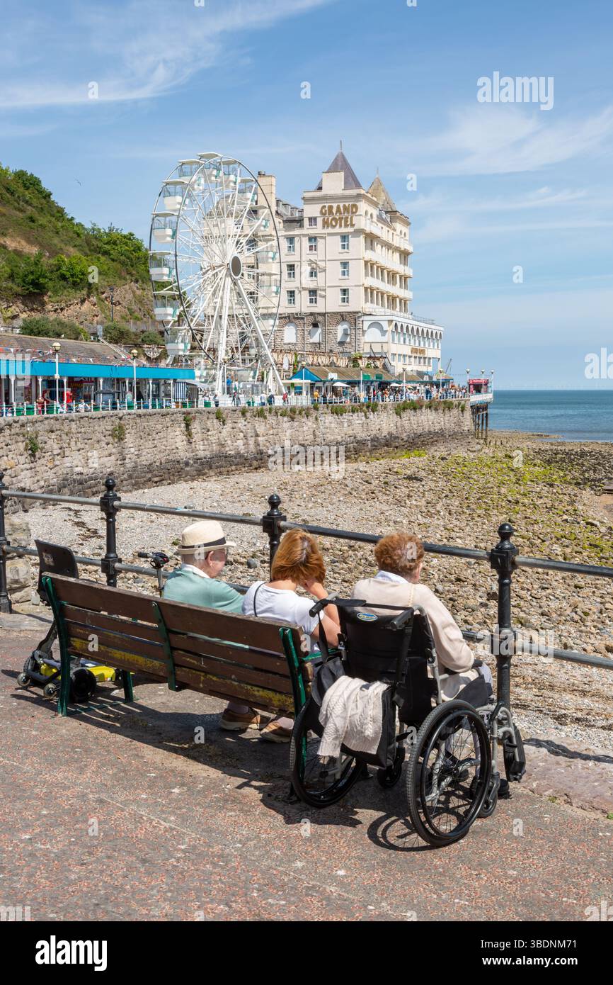 Persone sedute su panchine a Llandudno, Galles, regno unito. 2025 Foto Stock