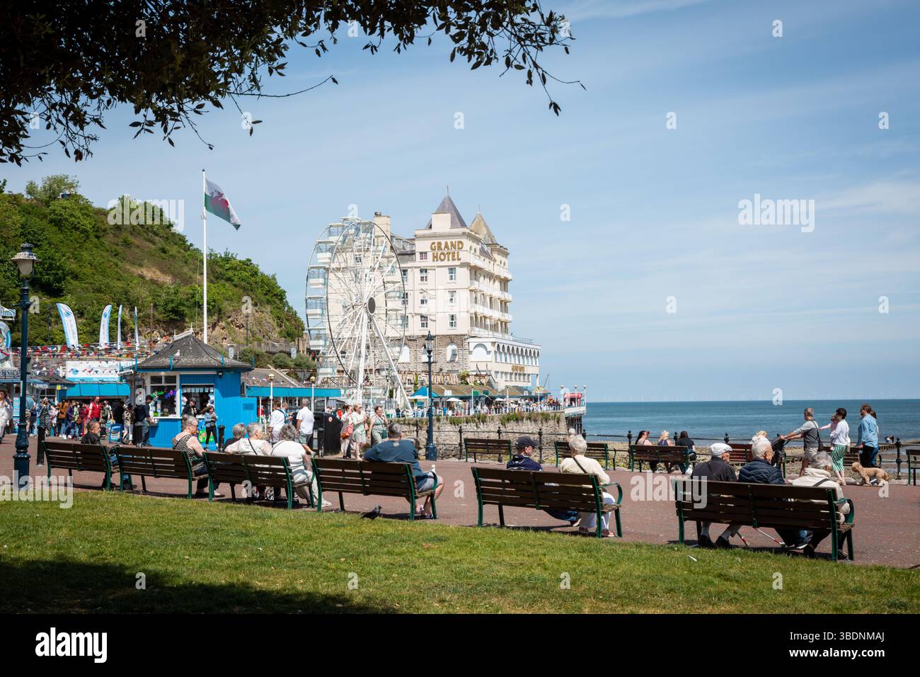 Persone sedute su panchine a Llandudno, Galles, regno unito. 2025 Foto Stock