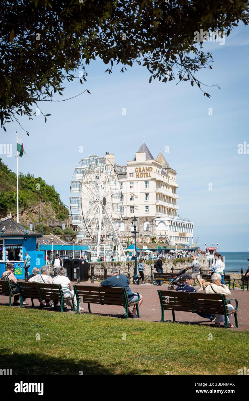 Persone sedute su panchine a Llandudno, Galles, regno unito. 2025 Foto Stock