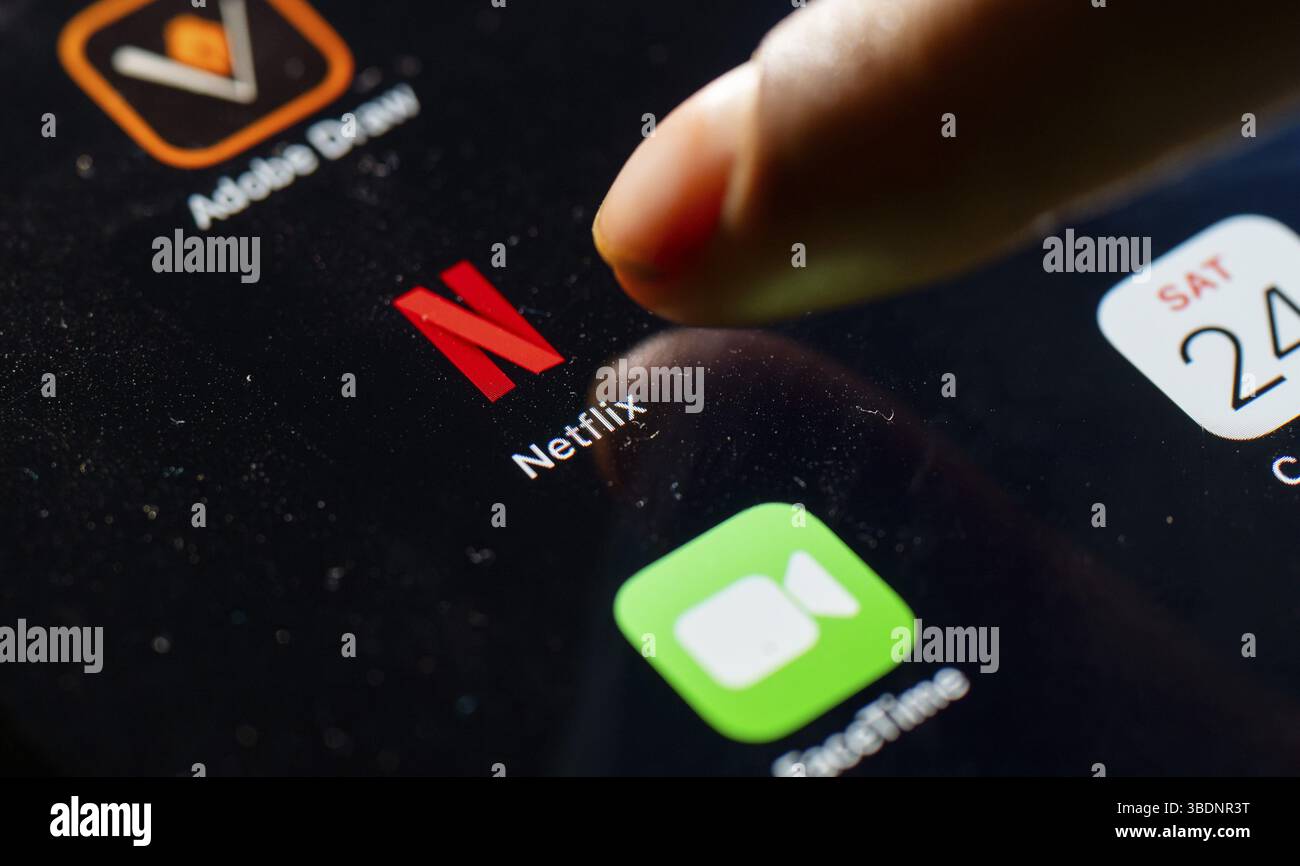 In questa foto, una persona tocca l'icona dell'app Netflix su un tablet il 24 maggio 2025 a nuova Delhi, India, Asia Foto Stock