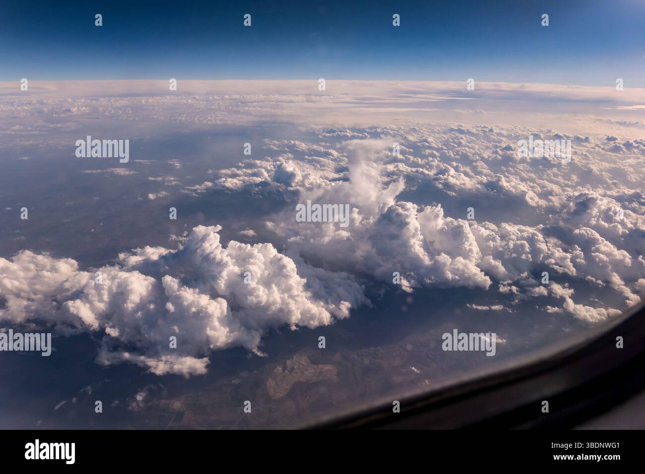 L'ala dell'aeroplano che vola in alto sopra le nuvole bianche e il cielo azzurro offre viste mozzafiato dell'atmosfera terrestre, creando un contrasto incredibile tra loro Foto Stock