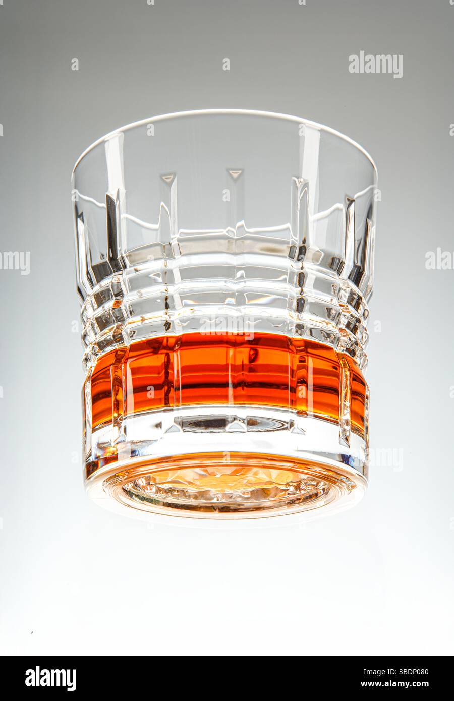 Foto eroica di un sofisticato bicchiere di whisky con ghiaccio sulle rocce, che mostra il ricco liquido ambrato. Foto Stock