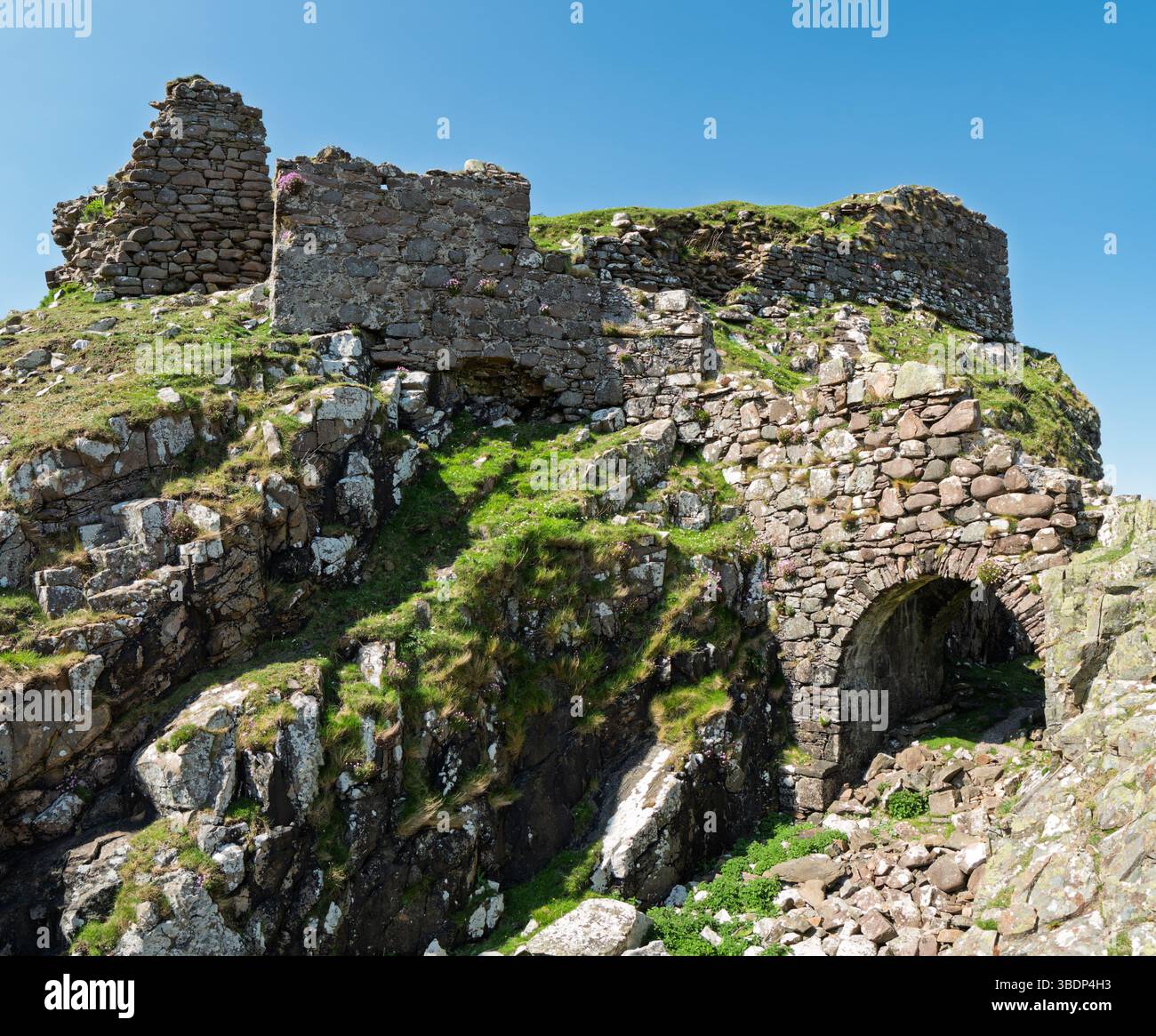 Le rovine di una collina scozzese/forte promontorio del castello di Dunscaith (Dun Scaich) con cielo azzurro limpido a maggio, Tokavaig, Isola di Skye, Scozia, Regno Unito. Foto Stock