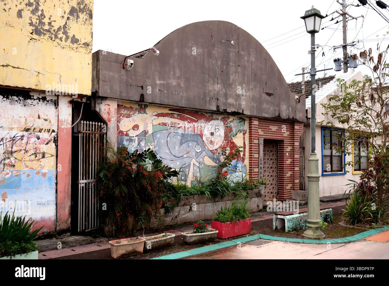 KIN Town liegt an der Ostküste der Insel Okinawa in Giappone und ist bekannt für Seine einzigartige Mischung aus traditioneller Kultur, militärischer Präsenz und kulinarischer Innovation. Die Nähe zu Camp Hansen, einem US-Marine-Stützpunkt, prägte die Stadt über Jahrzehnte hinweg. In den 1960er und 1970er Jahren War Kin Town besonders im Bereich Shinkaichi ein florierendes Unterhaltungszentrum mit bar, club e ristoranti, Die hauptsächlich US-Soldaten als Kunden hatten - heute kämpft die Stadt mit dem demografischen Wandel. KIN, 12.05.2025 Okinawa Giappone *** la città di Kin si trova nella parte est del coa Foto Stock