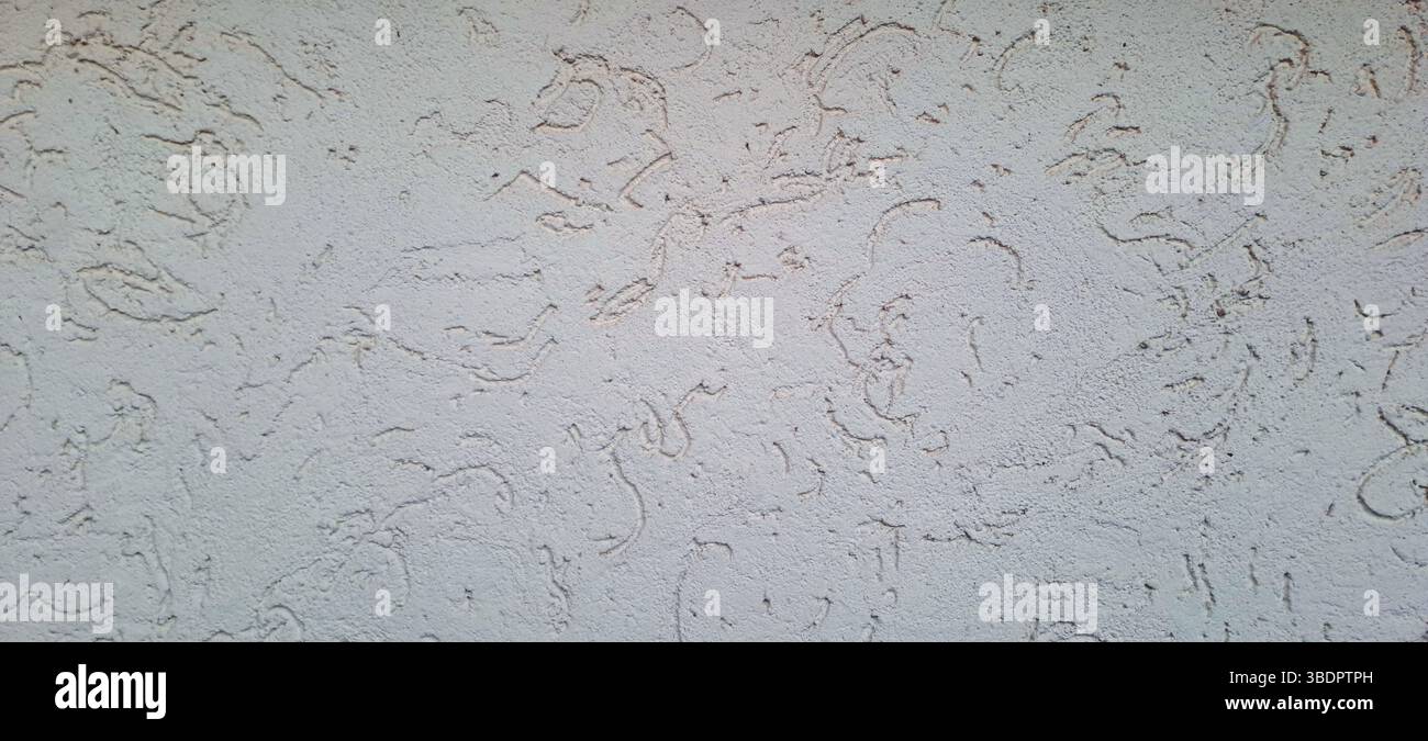 Intonaco decorativo che crea una texture unica sull'esterno di un edificio, aggiungendo interesse visivo e profondità Foto Stock