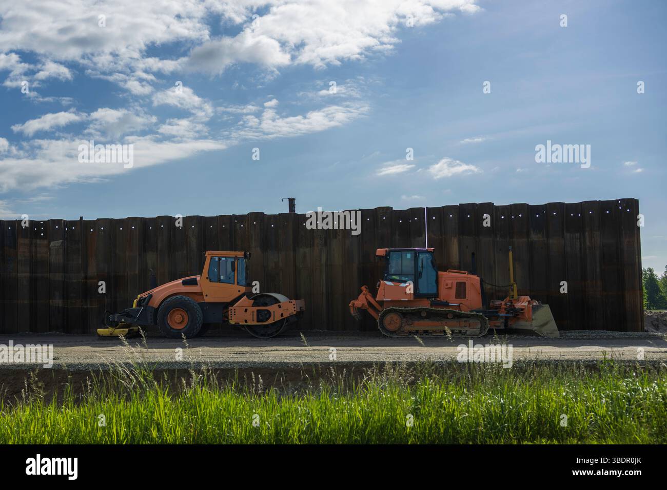 Macchinari da costruzione di fronte a una parete di pile di fogli Foto Stock
