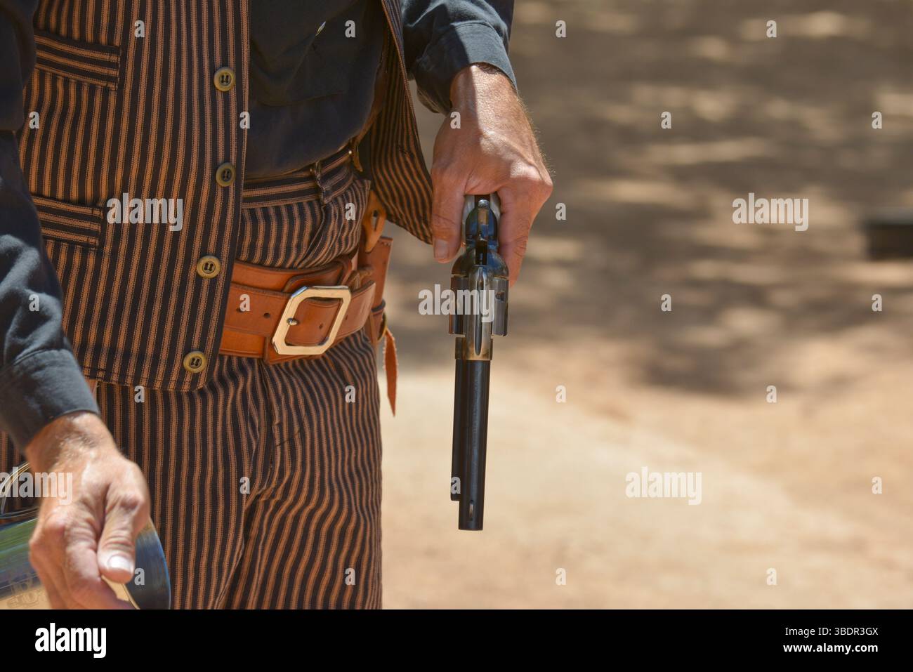 Cowboy Reenactor ricaricando il suo colt 45 per le strade di Tombstone, Arizona Foto Stock