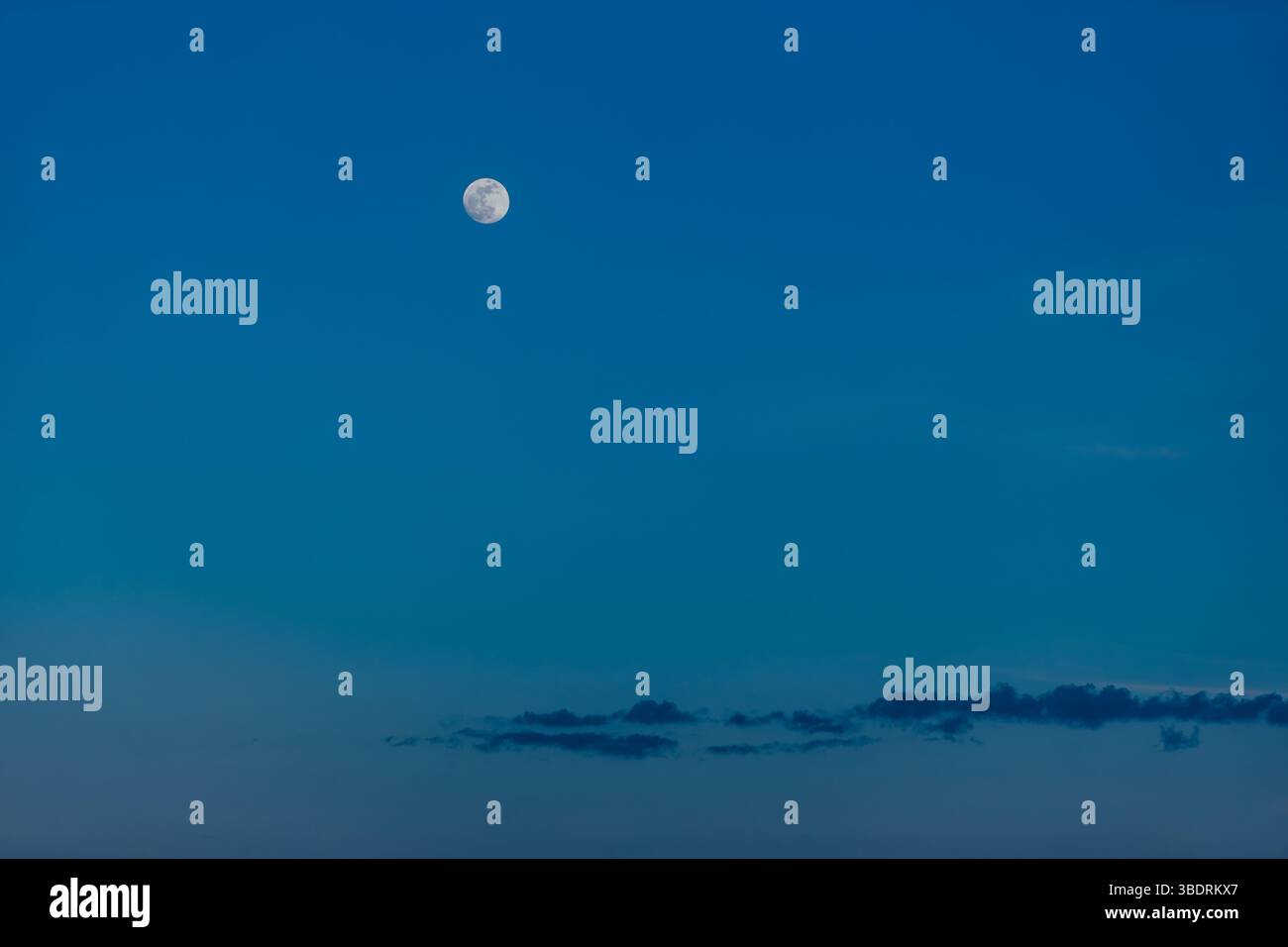 La luna risplende sul cielo crepuscolo con nuvole Foto Stock