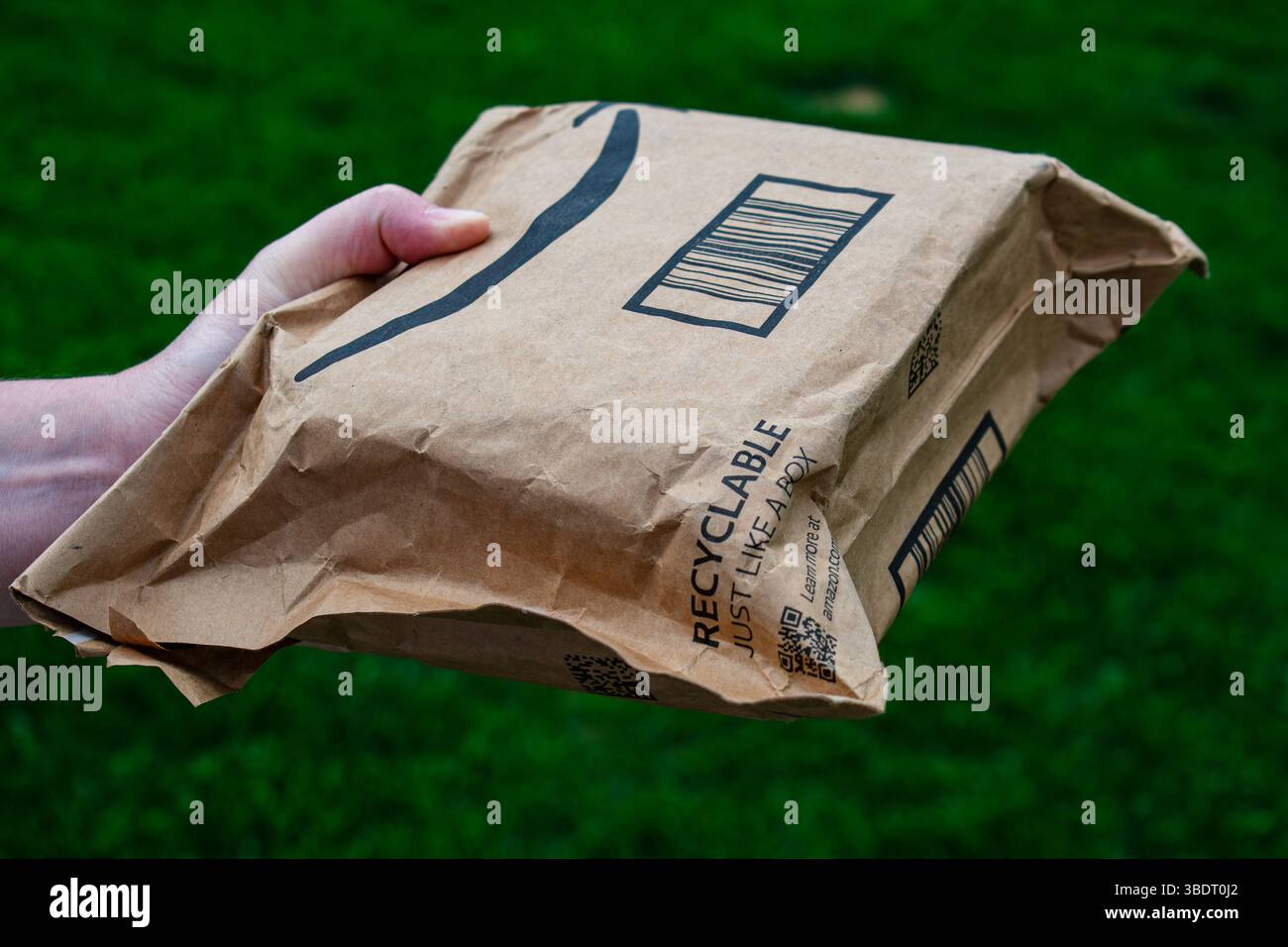 San Francisco, CA, USA – 24 maggio 2025: Una persona all'aperto detiene un pacchetto Amazon prime, simboleggiando la facilità e la popolarità del servizio di consegna di Amazon. Foto Stock