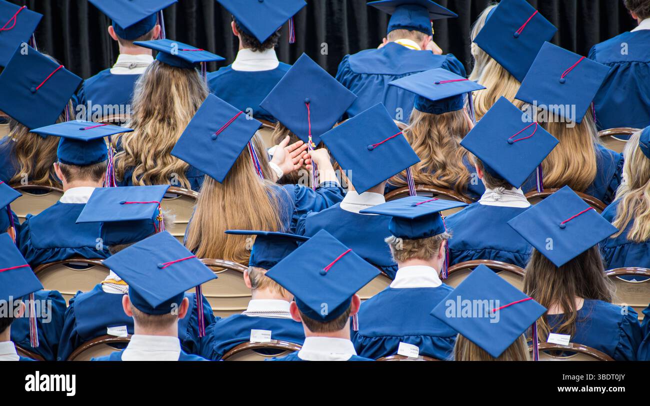 AMERICAN FORK, UT, USA – 24 MAGGIO 2025: Gli studenti che indossano cappelli di laurea si riuniscono in una scuola di American Fork, Utah, per celebrare i loro risultati. Foto Stock