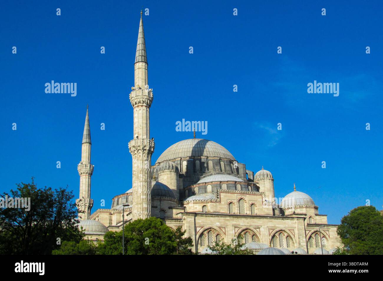 Moschea con alti minareti sulla costa del Bosforo a Istanbul, Turchia. Vista di Istanbul dal Bosforo, Turchia. Sagoma del minareto della moschea al tramonto Foto Stock