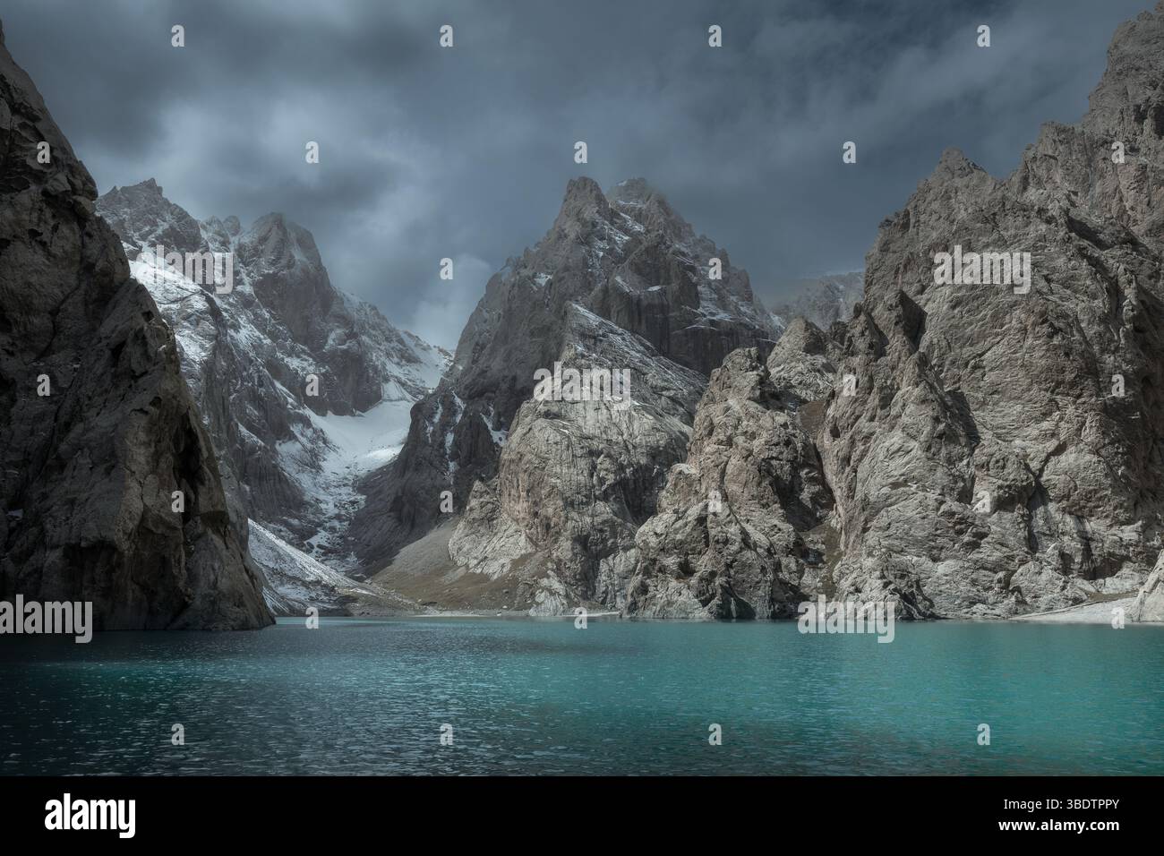 Vista panoramica di un lago turchese di Kel-Suu circondato da aspre vette innevate nelle remote zone della provincia di Naryn in Kirghizistan Foto Stock
