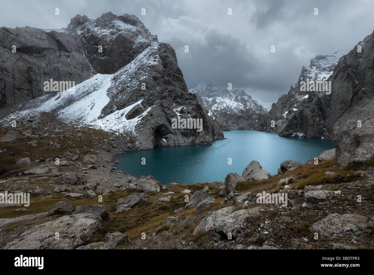 Vista panoramica di un lago turchese di Kel-Suu circondato da aspre vette innevate nelle remote zone della provincia di Naryn in Kirghizistan Foto Stock