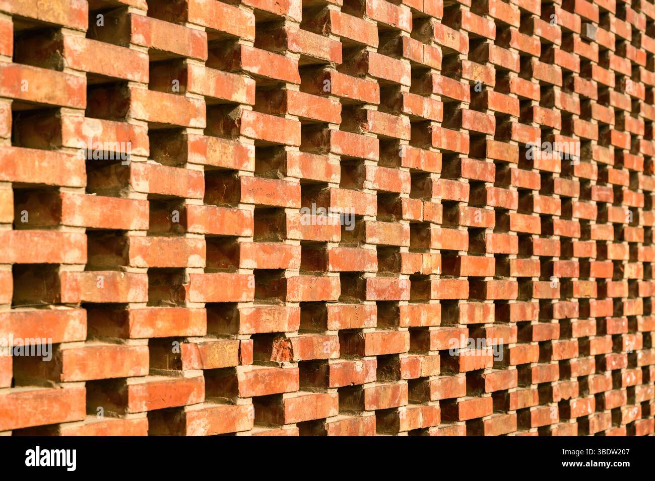 Parete in mattoni forati con motivo geometrico e design urbano. Messa a fuoco selettiva. Foto Stock