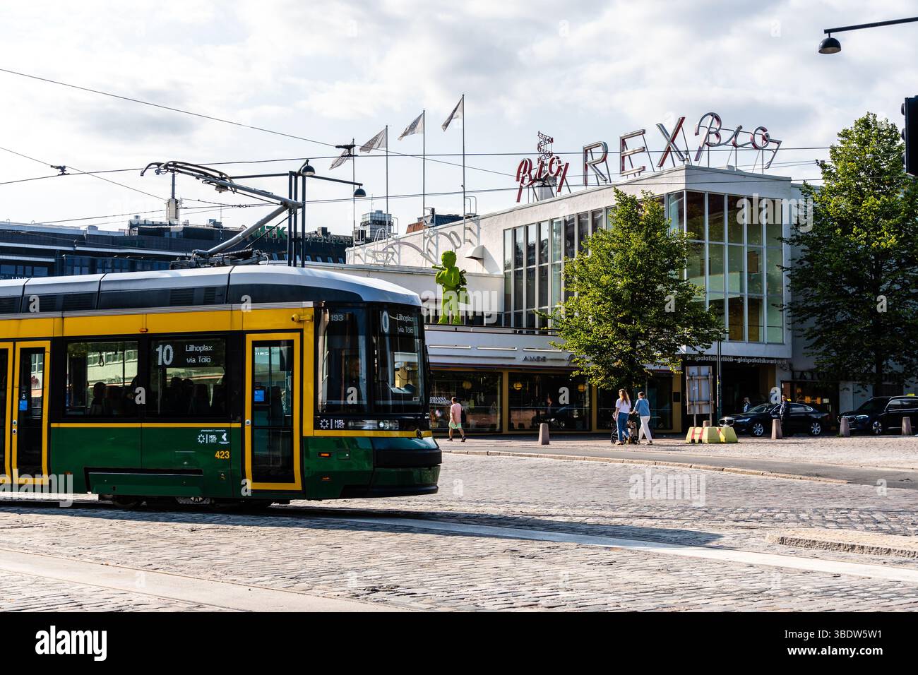 Helsinki, Finlandia - 19 agosto 2024: Una vista sulla strada a Helsinki, Finlandia, mostra un tram verde e giallo che passa di fronte allo storico Rex Bio ci Foto Stock