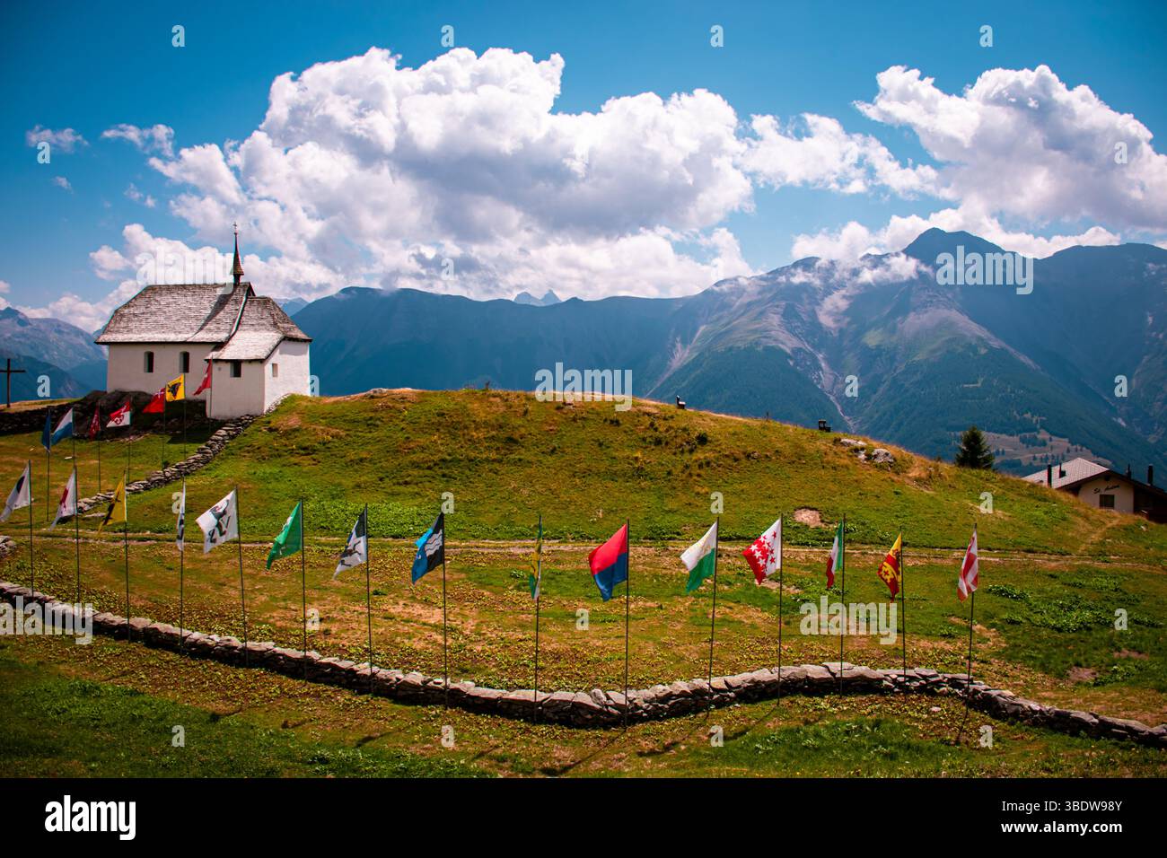 Affascinante piccola cappella di montagna immersa in un tranquillo ambiente alpino, che unisce la calma spirituale con una bellezza naturale mozzafiato e picchi aspri. Foto Stock