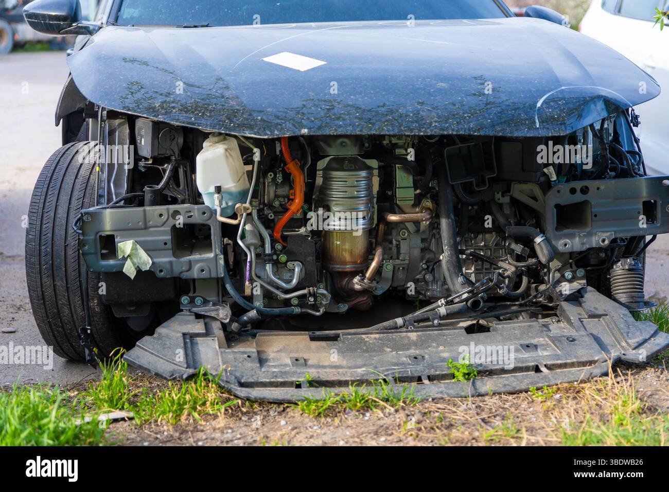 Primo piano di un'auto moderna con il paraurti anteriore rimosso, esponendo componenti complessi del motore, cablaggi e sistemi interni. Foto Stock