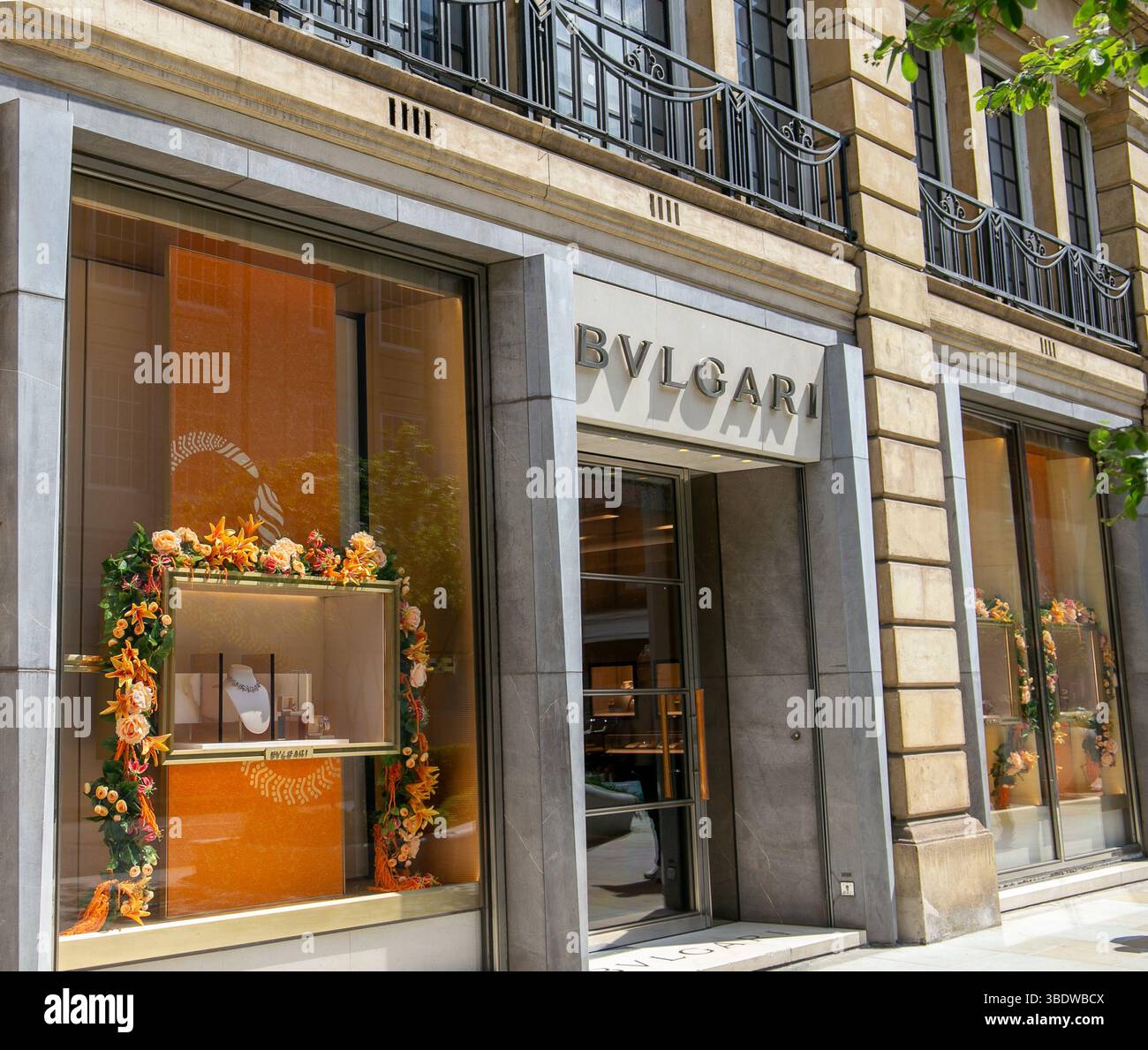Il Bvlgari si affaccia su Sloane St London con eleganti gioielli e decorazioni floreali in una giornata di sole in un edificio storico. Foto Stock