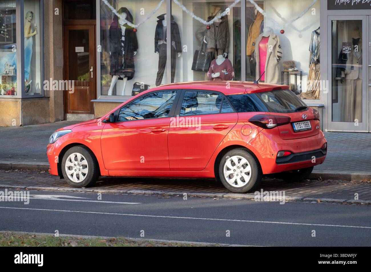 OSTRAVA, CECHIA - 18 DICEMBRE 2023: Vista posteriore laterale della Hyundai i20 II GB berlina rossa parcheggiata sulla strada Foto Stock