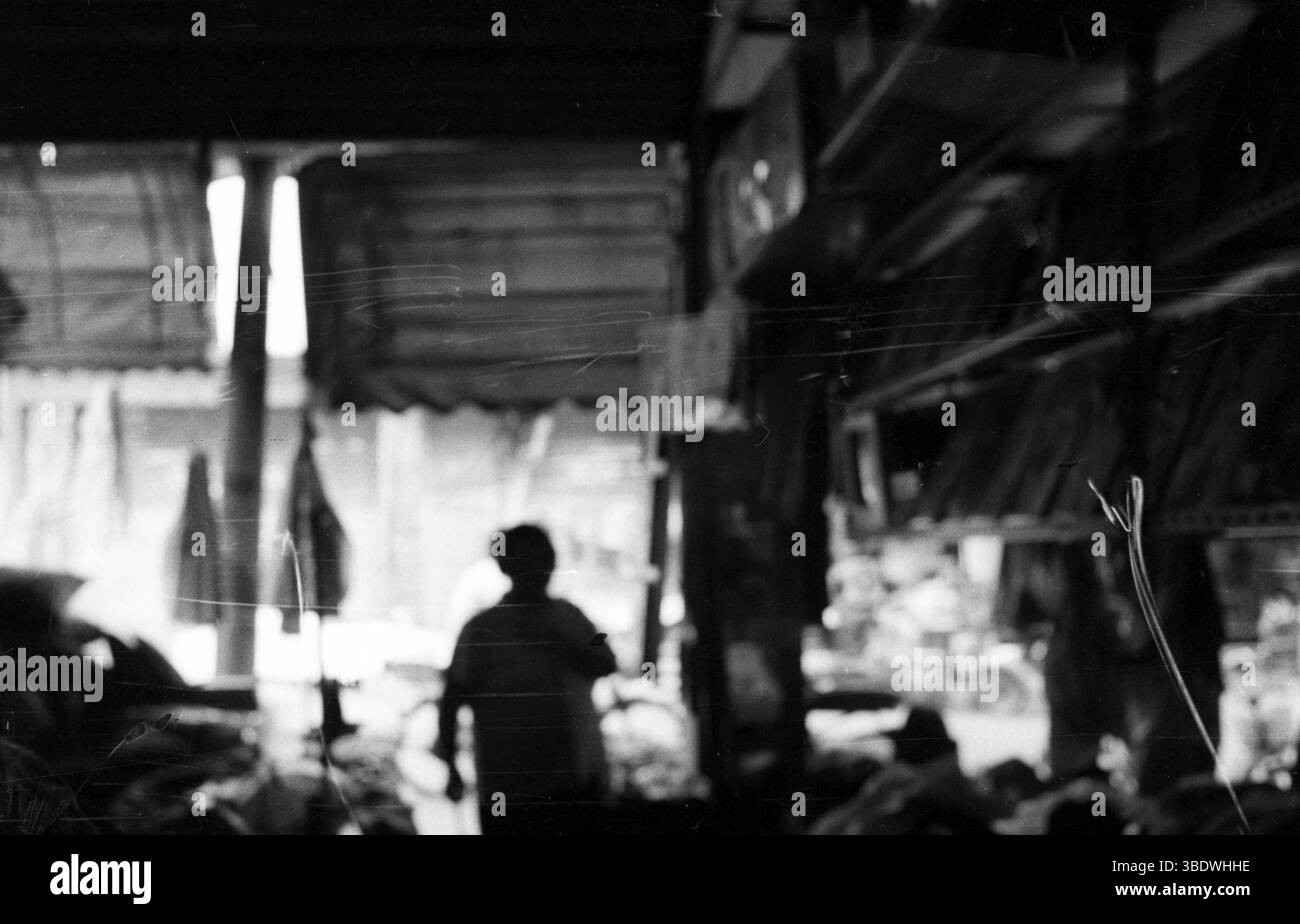 Silhouette sfocata nel mercato interno cinese - fotografia di strada in bianco e nero Foto Stock