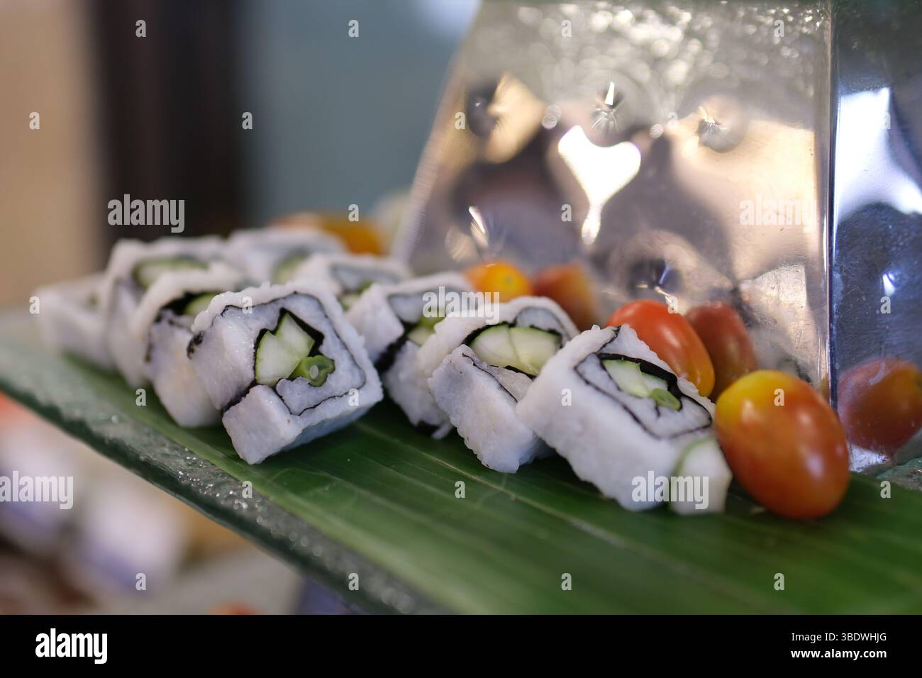 Sushi coreano, kimbap, con prosciutto, verdure e lattuga. Processo di cottura, preparazione del kimbap fatto in casa, cottura passo dopo passo e taglio a fette con le mani nella foto, vista dall'alto Foto Stock