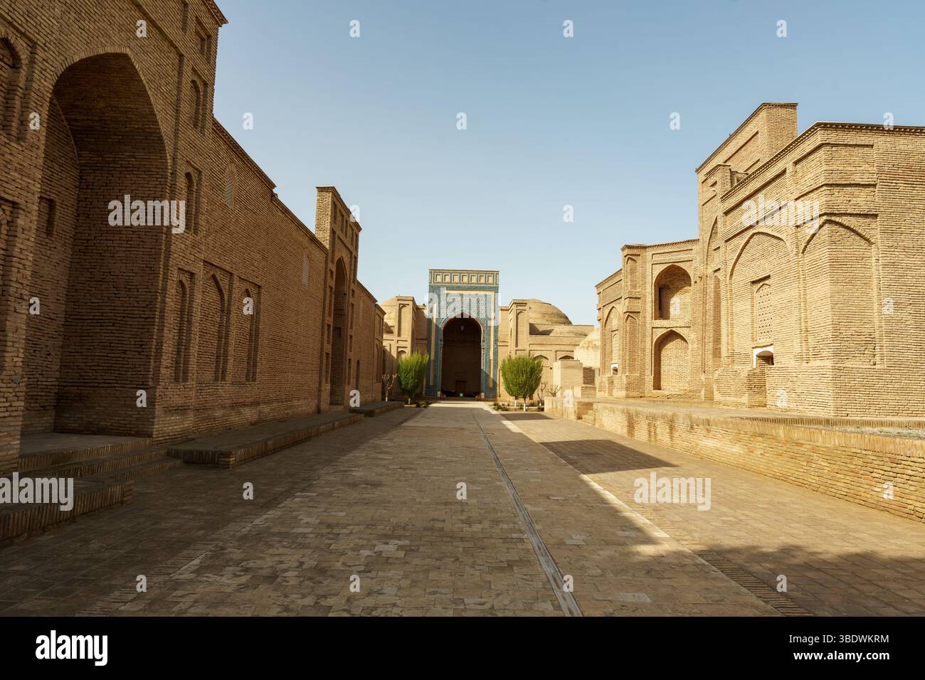 Una strada stretta con un arco blu che conduce ad un edificio Foto Stock