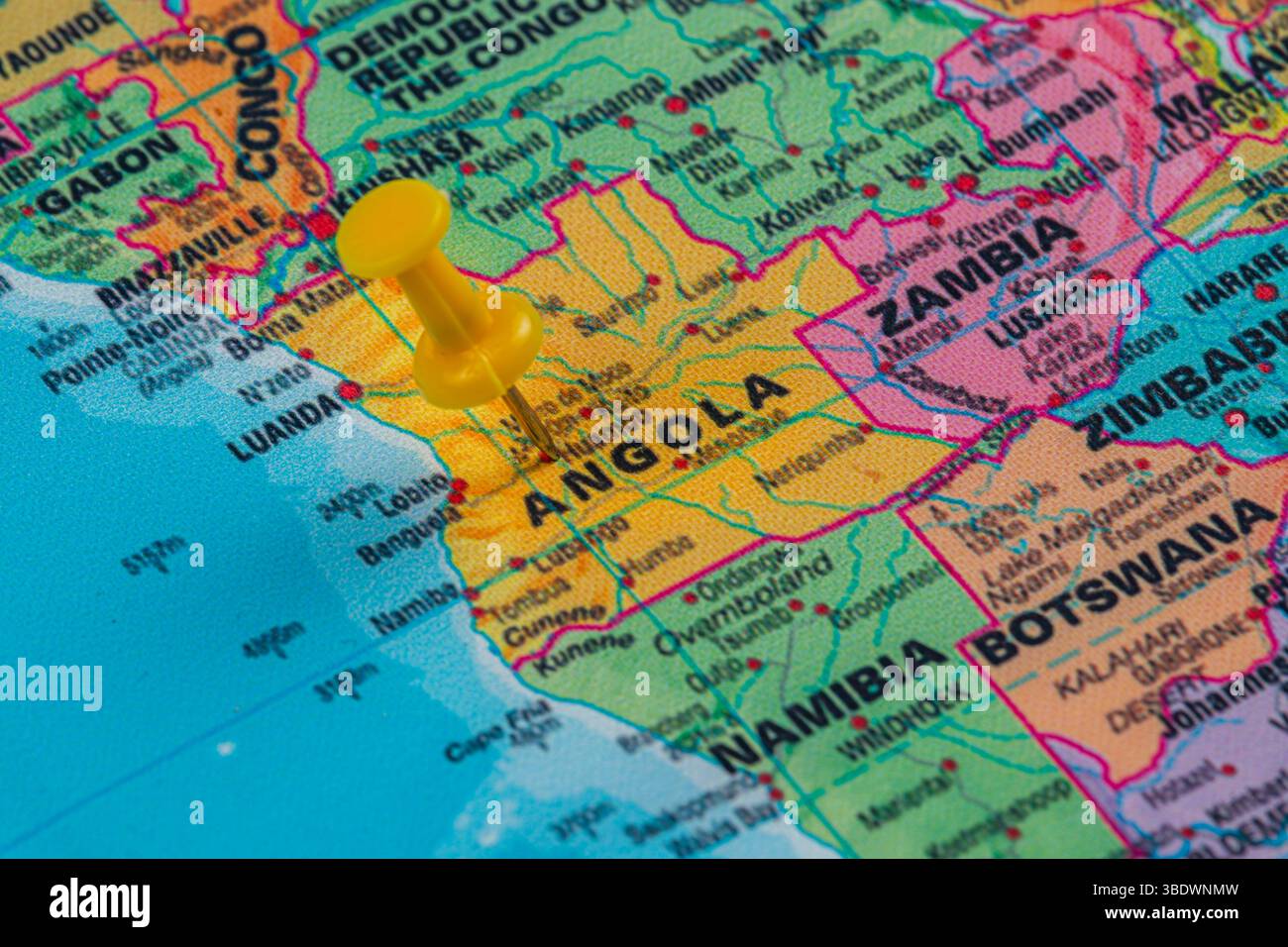 Una spilla gialla segna l'Angola su una mappa colorata, mostrando i paesi vicini e le caratteristiche geografiche per scopi educativi o di viaggio pla Foto Stock Una spilla gialla segna l'Angola su una mappa colorata, mostrando i paesi vicini e le caratteristiche geografiche per scopi educativi o di viaggio pla Foto Stock