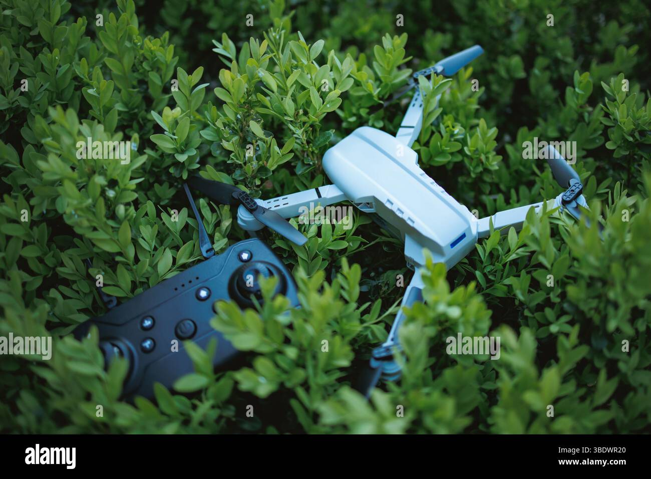 Drone con telecomando su un cespuglio. L'immagine può essere utilizzata in uno spot pubblicitario. Foto Stock