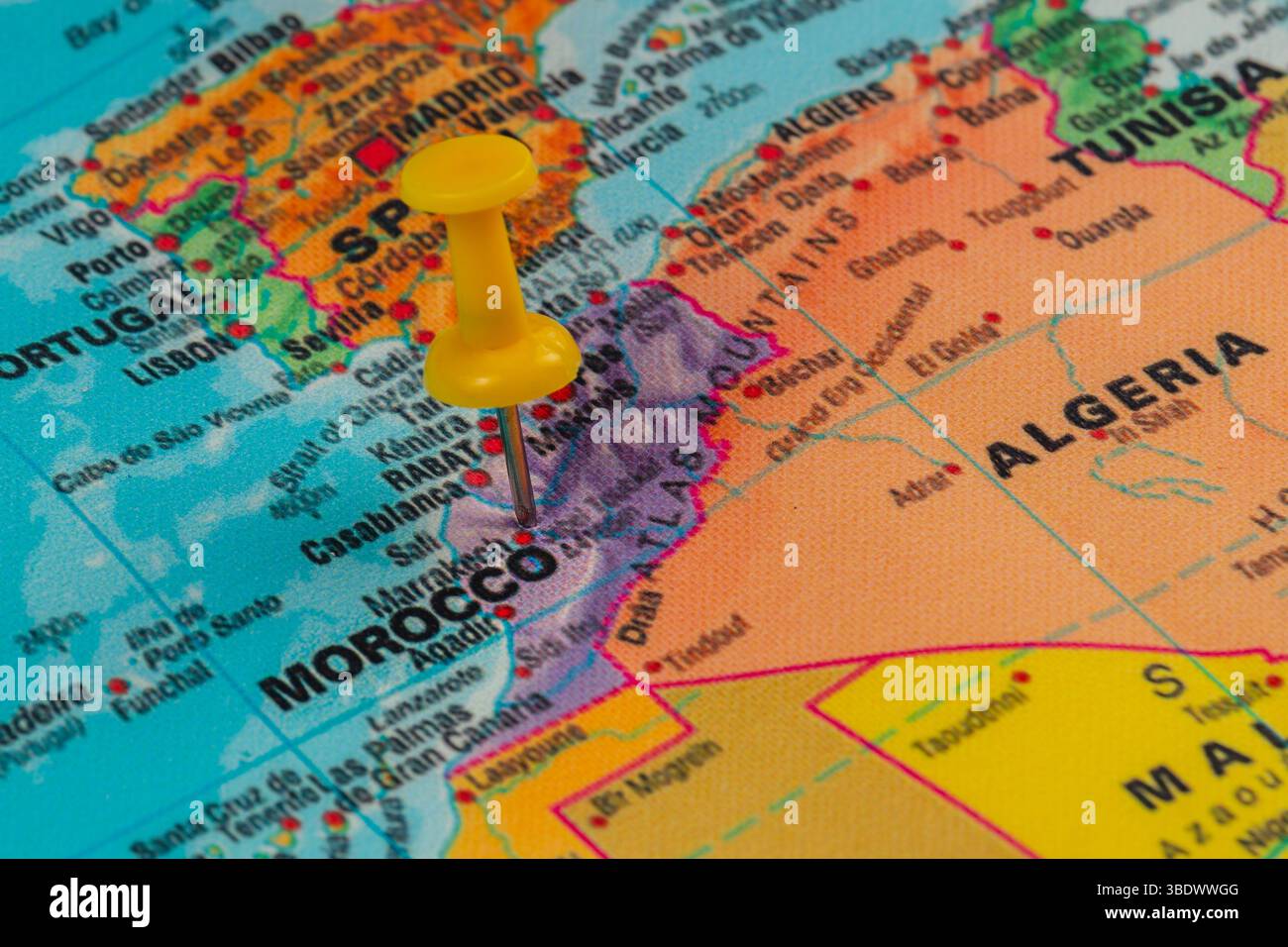 Una spilla gialla segna la posizione del Marocco su una mappa colorata del Nord Africa. La mappa mostra paesi vicini come Algeria e Tunisia Foto Stock Una spilla gialla segna la posizione del Marocco su una mappa colorata del Nord Africa. La mappa mostra paesi vicini come Algeria e Tunisia Foto Stock
