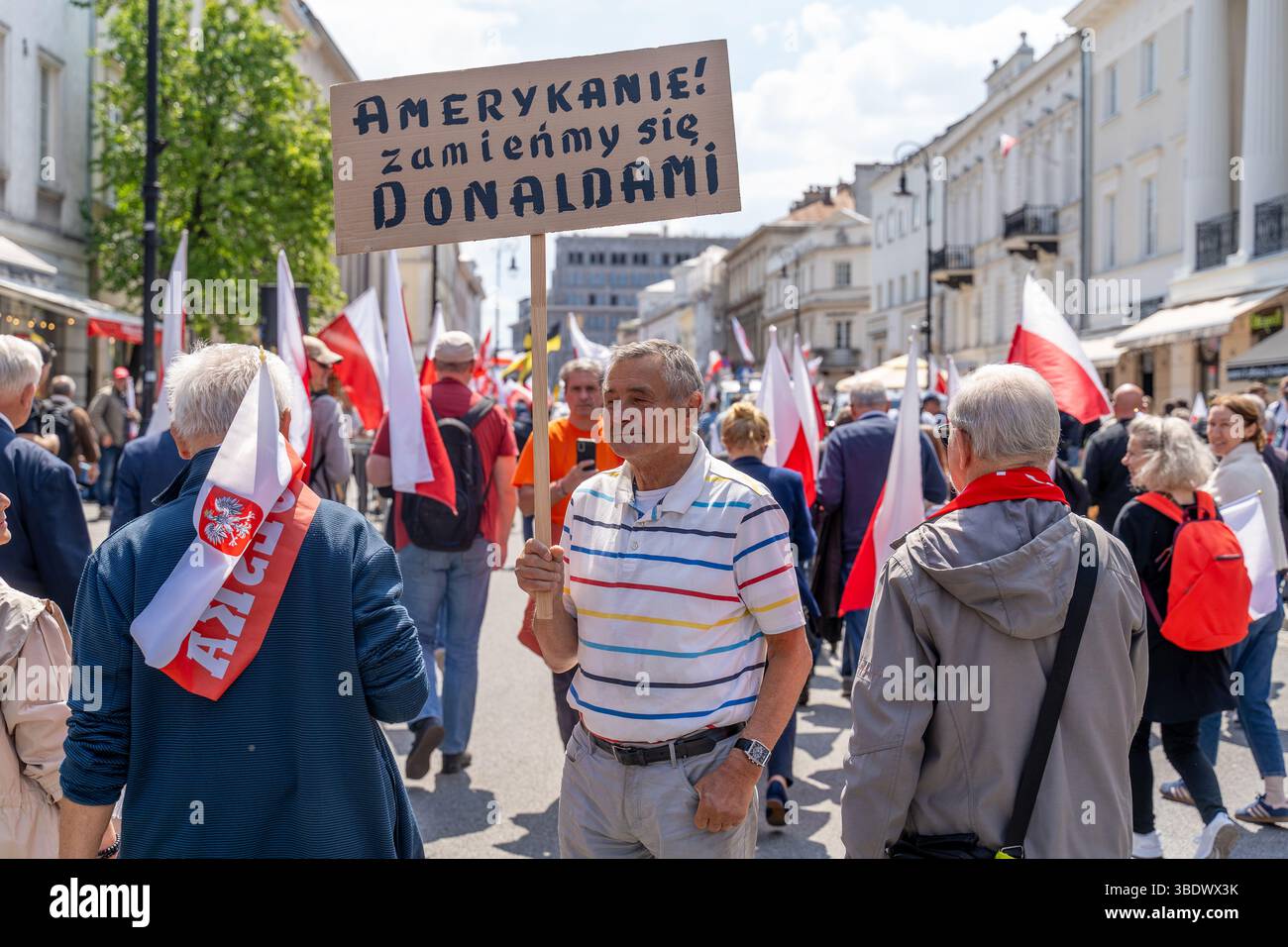Un dimostratore ha un cartello che dice "americani, scambiamoci i nostri Donalds". Durante la marcia per la Polonia, una settimana prima del secondo turno delle elezioni presidenziali del 25 maggio 2025. I leader delle elezioni presidenziali polacche stanno organizzando marce rivali a Varsavia prima del ballottaggio del 1° giugno. Rafa? Trzaskowski, il sindaco liberale di Varsavia sostenuto dal primo ministro Donald Tusk, ottenne il 31,4% dei voti nel primo turno il 18 maggio. Karol Nawrocki, rappresentante del Partito per la giustizia e la legge (PiS), ha ricevuto il 29,5%. Le elezioni sono viste come una prova per verificare se il valore del centrista del governo Foto Stock