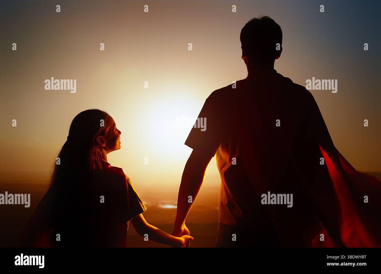 Famiglia felice amorevole. Padre e sua figlia giocano all'aperto. Daddy e la sua bambina in costumi di un Supereroe. Foto Stock