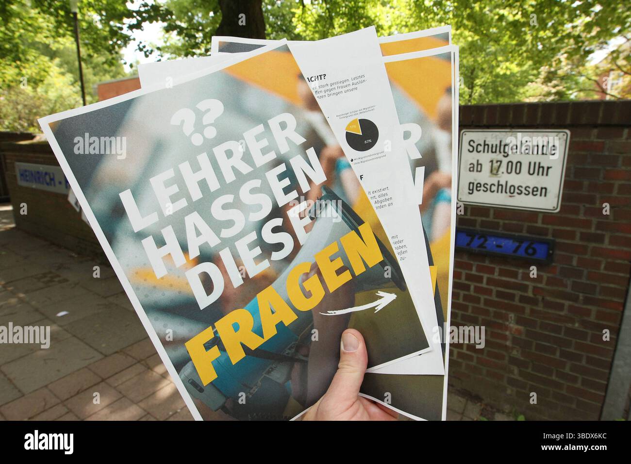 Ein Mann hält vor einer Schule einen Flyer der Identitären Bewegung zum Thema Remigration in der Hand. Auf der Vorderseite steht dabei lediglich der Satz: Lehrer hassen diese Fragen , auf der Fünf sind Rückseite kurze Fragen mit Antworten abgedruckt. Simbolo/simbolo foto. Winterhude Hamburg *** Un uomo tiene un volantino del movimento Identitariano sul tema della remigrazione di fronte a una scuola sul fronte c'è solo la frase che gli insegnanti odiano queste domande, sul retro ci sono cinque brevi domande con risposte immagine simbolica immagine simbolica Winterhude Hamburg Foto Stock