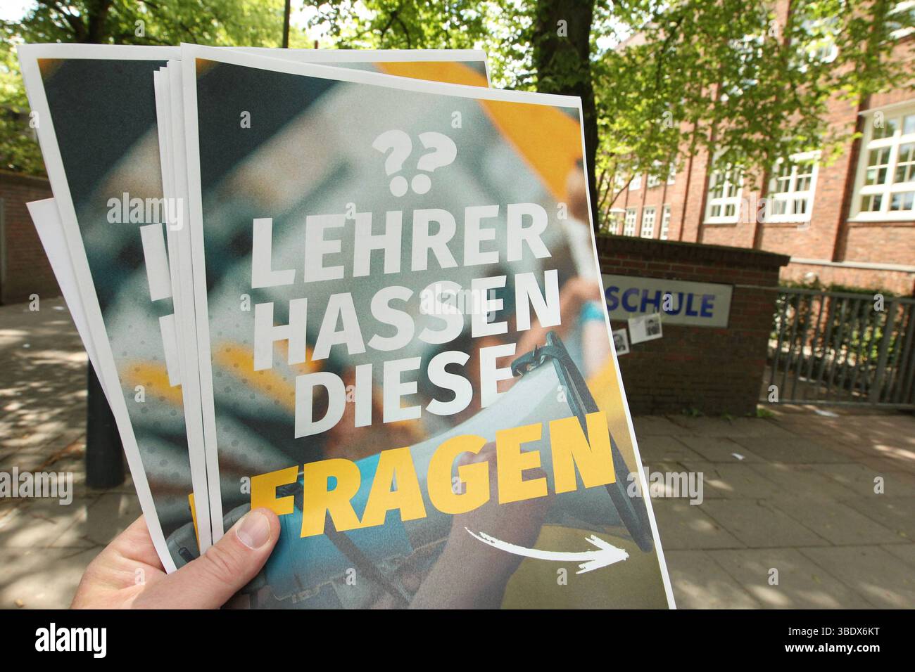 Ein Mann hält vor einer Schule einen Flyer der Identitären Bewegung zum Thema Remigration in der Hand. Auf der Vorderseite steht dabei lediglich der Satz: Lehrer hassen diese Fragen , auf der Fünf sind Rückseite kurze Fragen mit Antworten abgedruckt. Simbolo/simbolo foto. Winterhude Hamburg *** Un uomo tiene un volantino del movimento Identitariano sul tema della remigrazione di fronte a una scuola sul fronte c'è solo la frase che gli insegnanti odiano queste domande, sul retro ci sono cinque brevi domande con risposte immagine simbolica immagine simbolica Winterhude Hamburg Foto Stock