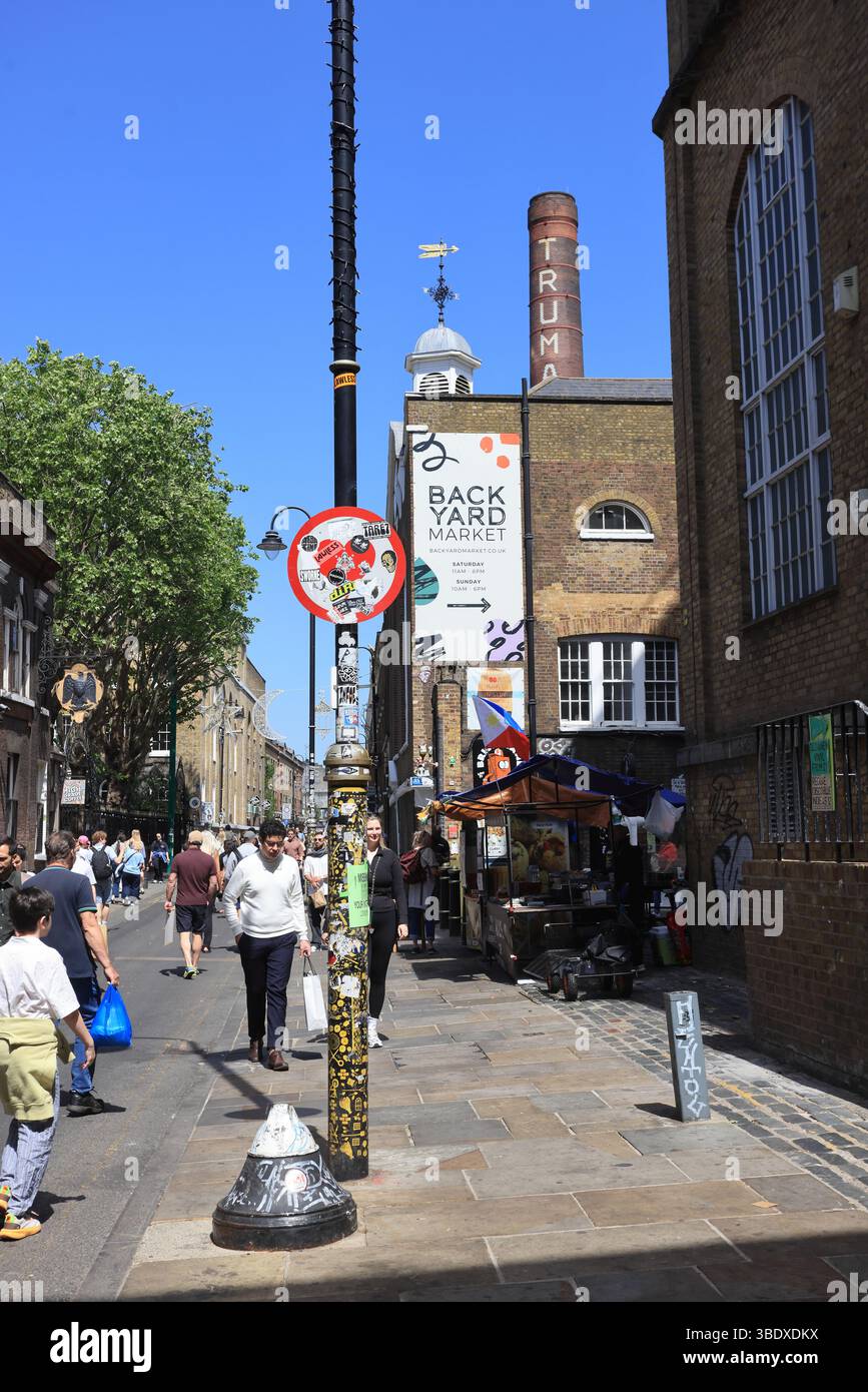 Vivace Brick Lane nella zona est di Londra, famosa per le sue case al curry, i negozi di bagel, la Street art e i mercati, famosa destinazione 4 turisti e locali, Regno Unito Foto Stock