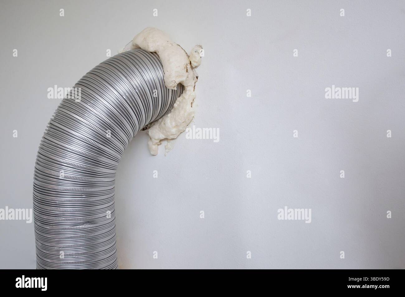 Installazione della cappa di ventilazione del bruciatore a gas con un tubo flessibile e un foro nella parete Foto Stock