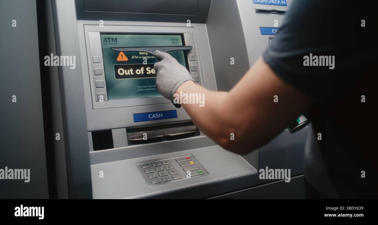 Pulizia pulizia dello schermo bancomat vandalizzato con Rag, rimozione di graffiti, etichette scarabocchiate da distributore automatico, bancomat. Servizio di pulizia, danni alla proprietà, atti vandalici delle apparecchiature bancarie pubbliche. Foto Stock