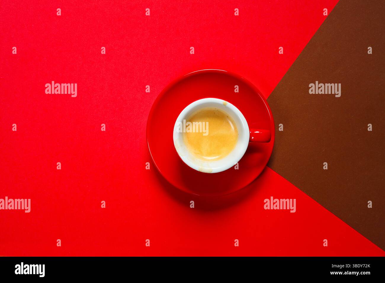 Tazza espresso con piattino su fondo bicolore con delizioso caffè espresso appena estratto. Spazio libero per le copie. Foto Stock