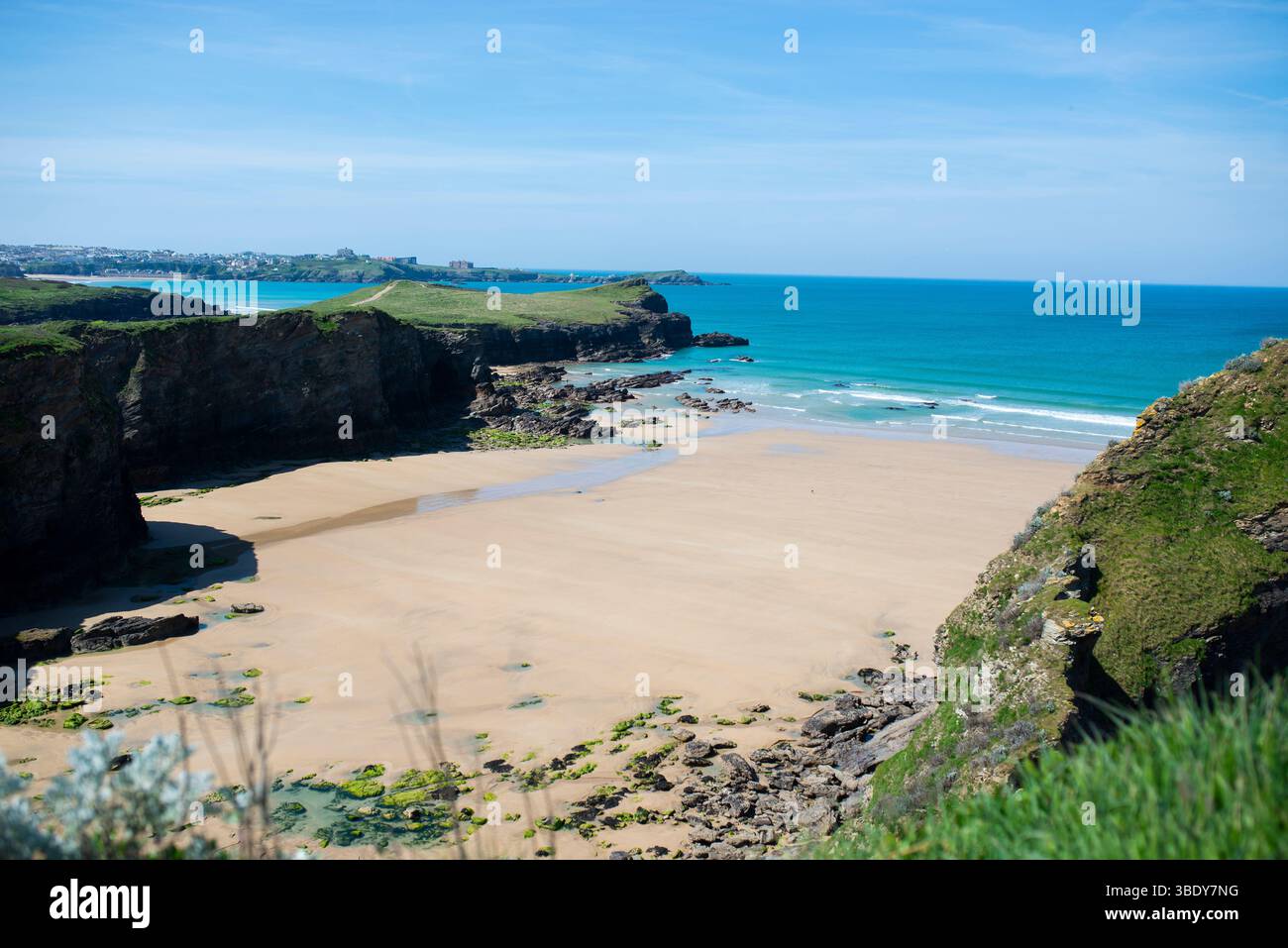 Isolata Whipsiderry Beach vicino a Newquay, Cornovaglia, con sabbia dorata, scogliere spettacolari e acque turchesi durante la bassa marea. Foto Stock