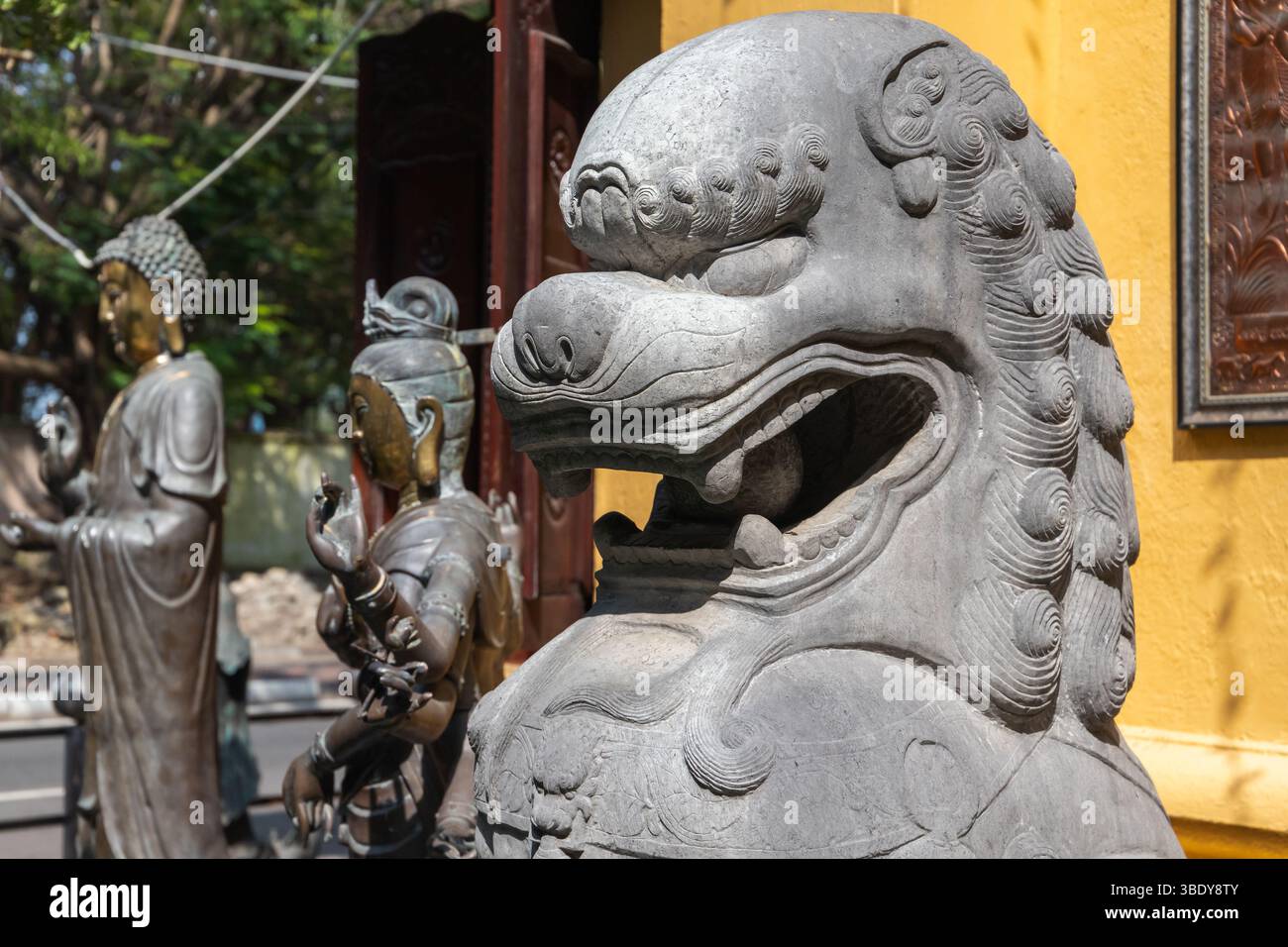 Tempio Gangaramaya, Colombo, Sri Lanka. Statua decorativa in pietra del leone che circonda una scena con sculture di Buddha in un ambiente culturale all'aperto Foto Stock