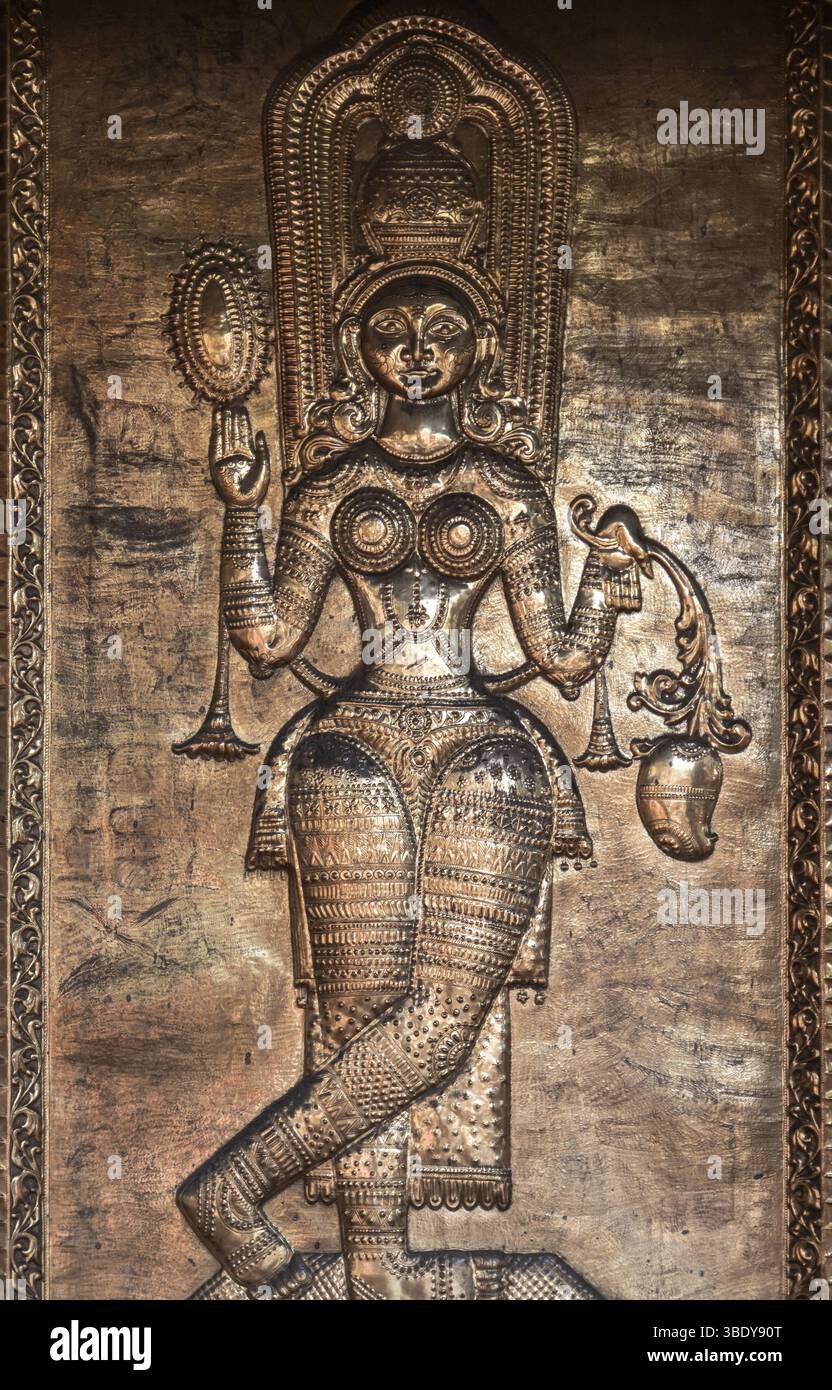 Artistico rilievo metallico che raffigura una divinità adornata in modo intricato, simboleggia la cultura e la spiritualità attraverso l'artigianato tradizionale. Gangaramaya te Foto Stock