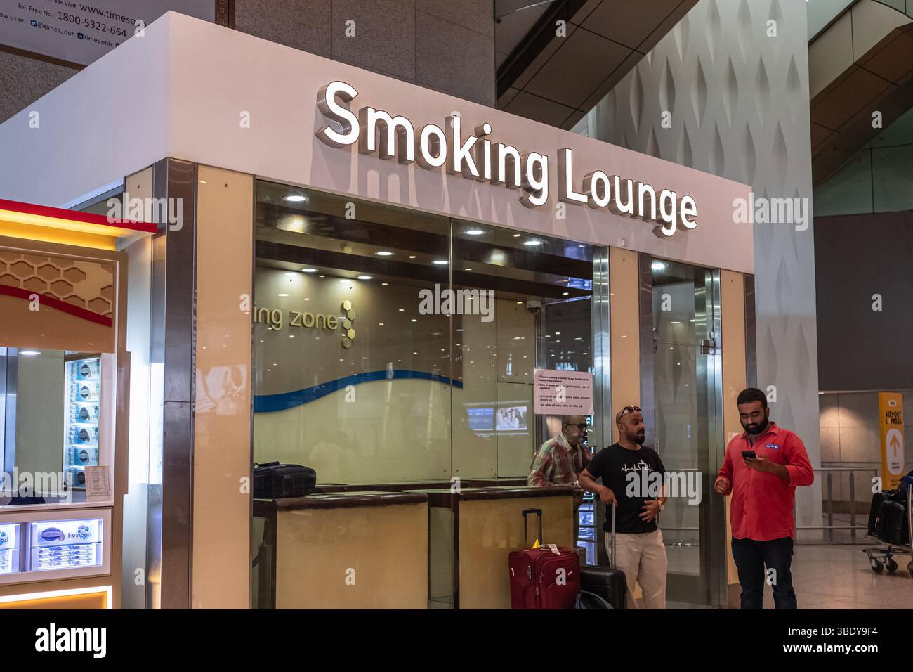 Cantate su una sala fumatori a muro. Lounge fumatori con persone all'interno dell'Aeroporto Internazionale di Mumbai India. All'interno del terminal dell'aeroporto. Trave Foto Stock Cantate su una sala fumatori a muro. Lounge fumatori con persone all'interno dell'Aeroporto Internazionale di Mumbai India. All'interno del terminal dell'aeroporto. Trave Foto Stock